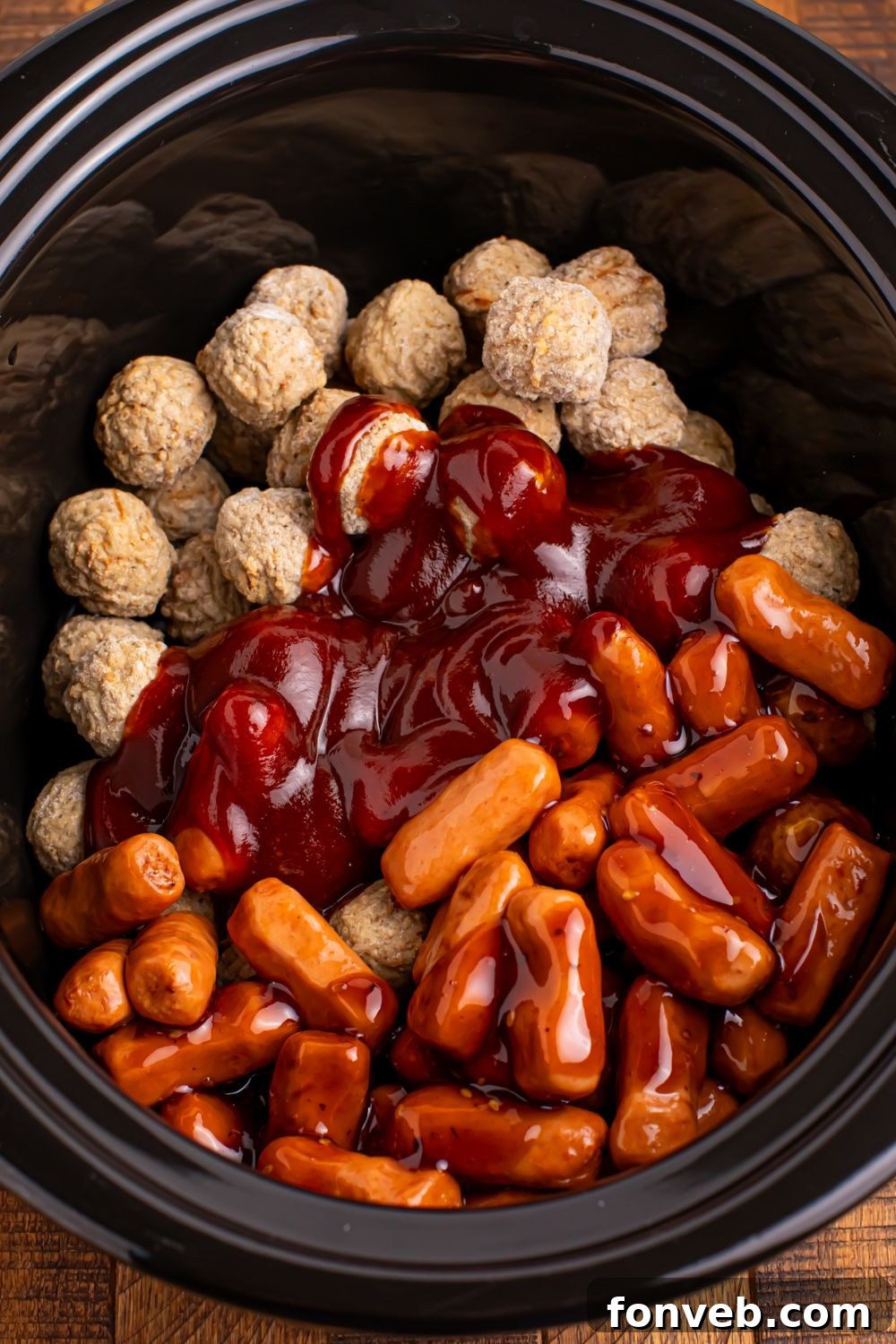 Crockpot Teriyaki BBQ Cocktail Meatballs & Lil Smokies being dumped into a slow cooker and yet to be stirred up