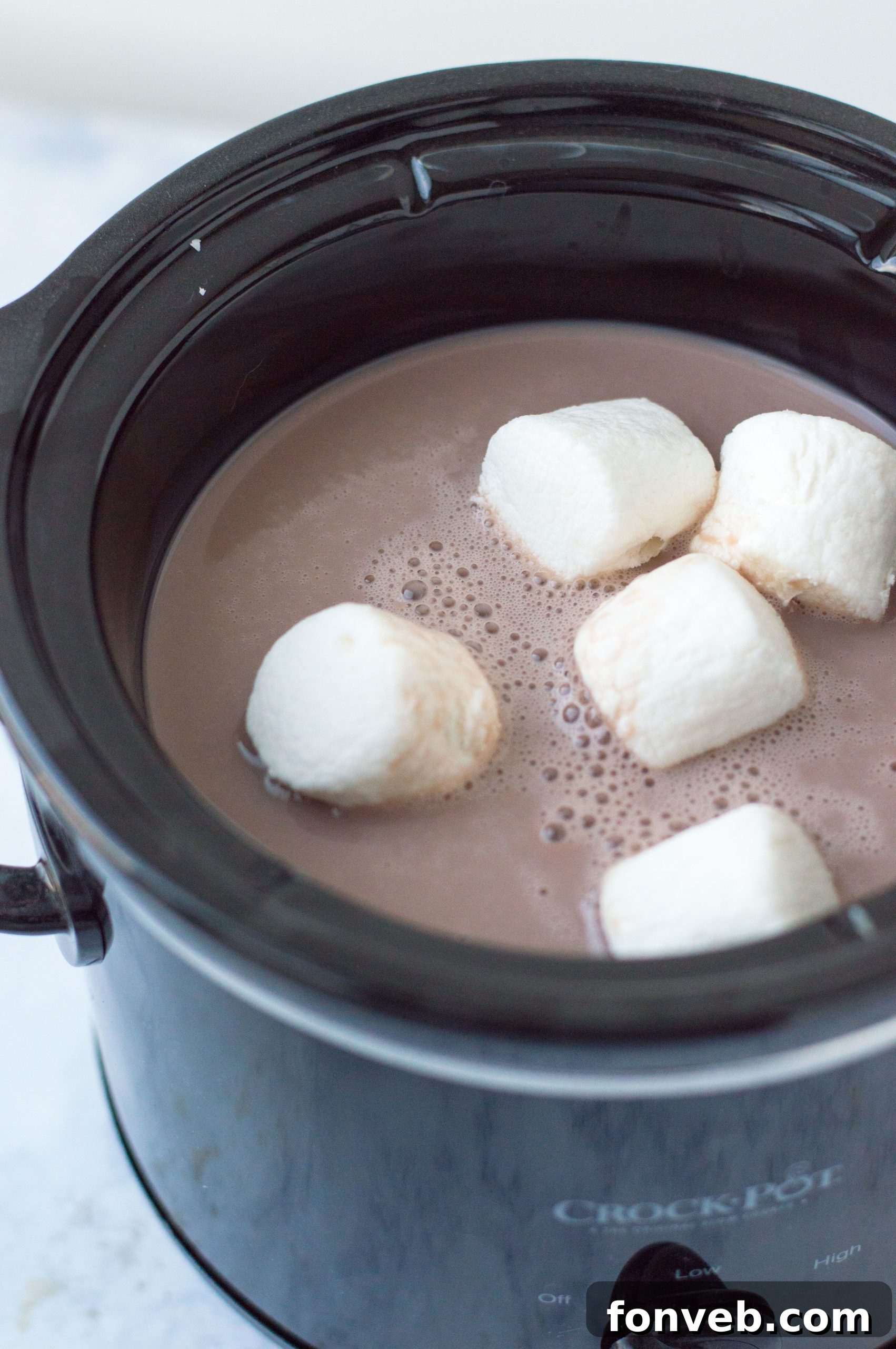 A warm slow cooker brimming with homemade hot chocolate, ready for a festive gathering.
