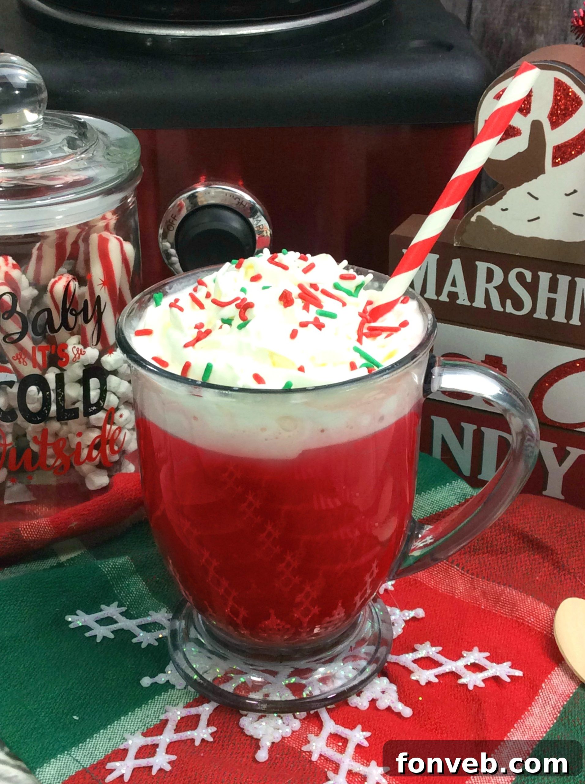 Two mugs of Red Velvet Hot Chocolate, adorned with whipped cream, sprinkles, and candy canes, set against a festive backdrop.