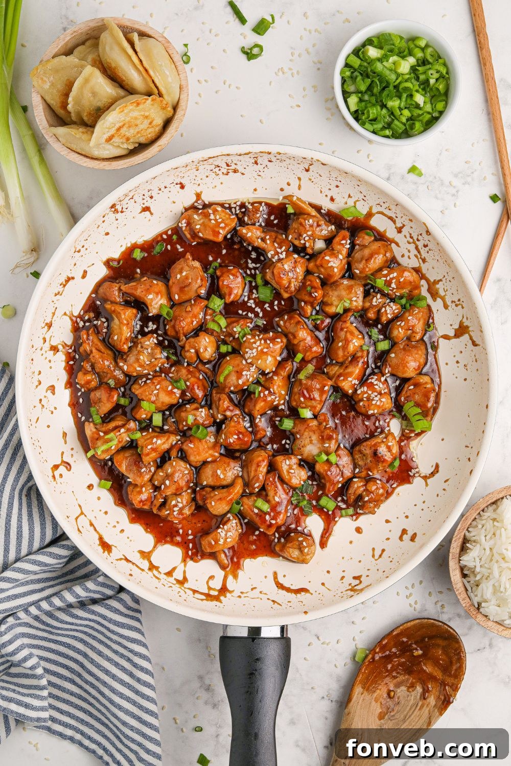Irresistible Bourbon Chicken Skillet Quick Weeknight Win 13 a skillet on the table with diced Bourbon Chicken Skillet to the side and green onions to the side on the plate