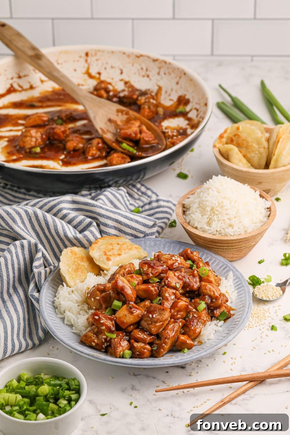 Irresistible Bourbon Chicken Skillet Quick Weeknight Win 14 Bourbon Chicken in a skillet with a plate full of chicken and rice in front, a bowl of rice, and pieorgi's as well all on a dinner table