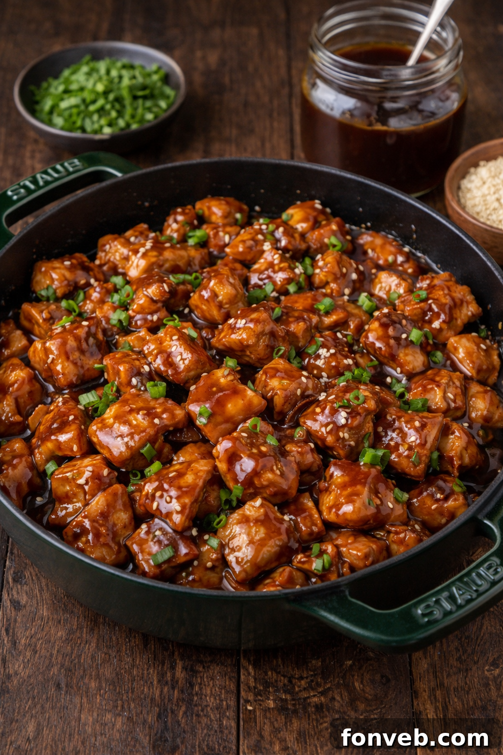 Irresistible Bourbon Chicken Skillet Quick Weeknight Win 16 Bourbon Chicken in a green staub skillet covered in sesame seeds and chives