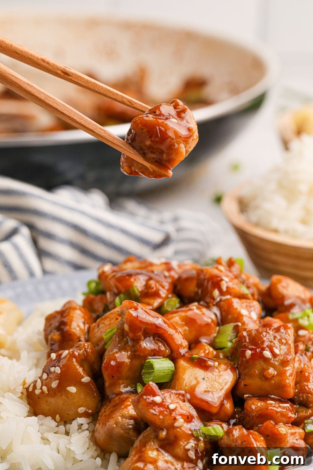 Irresistible Bourbon Chicken Skillet Quick Weeknight Win 20 Bourbon Chicken on a plate with some chopsticks lifting a piece of chicken out of the plate