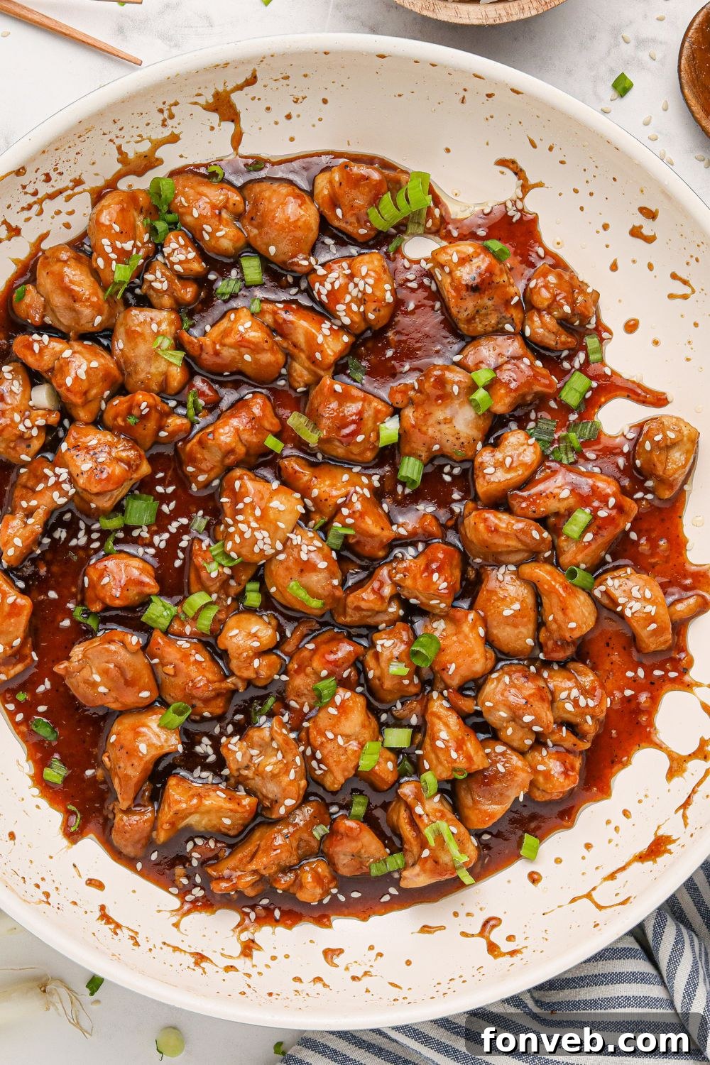 Irresistible Bourbon Chicken Skillet Quick Weeknight Win 22 side view of a white skillet on table full of saucy bourbon chicken