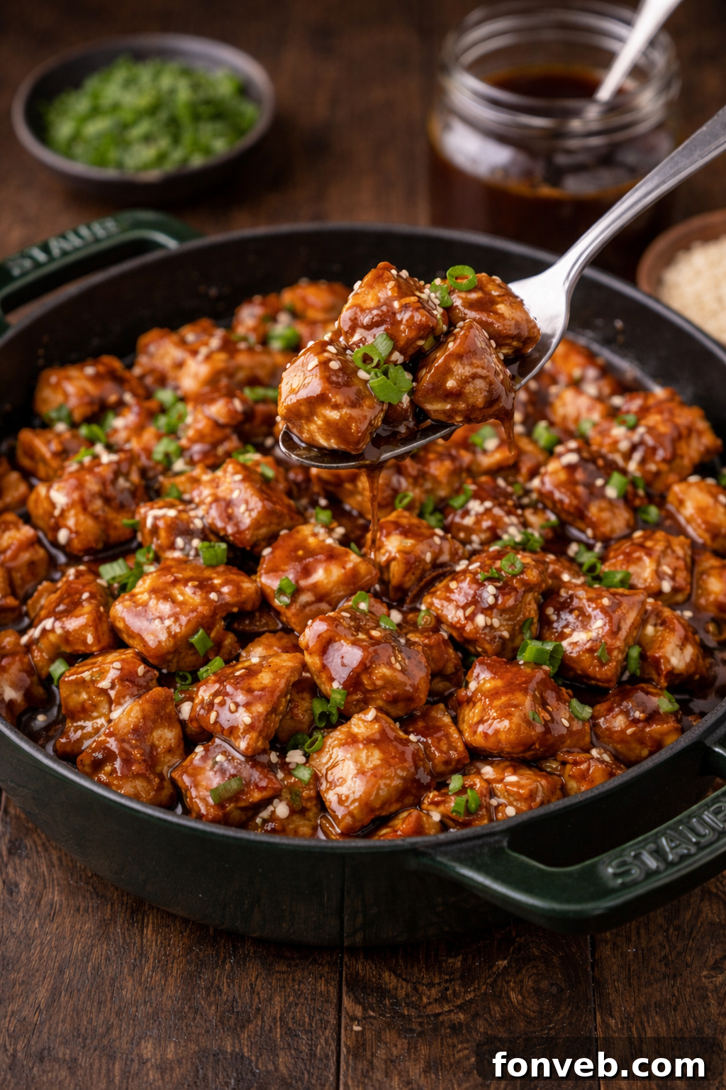 Irresistible Bourbon Chicken Skillet Quick Weeknight Win 5 Bourbon Chicken in a green staub skillet with a spoon lifting up a bite