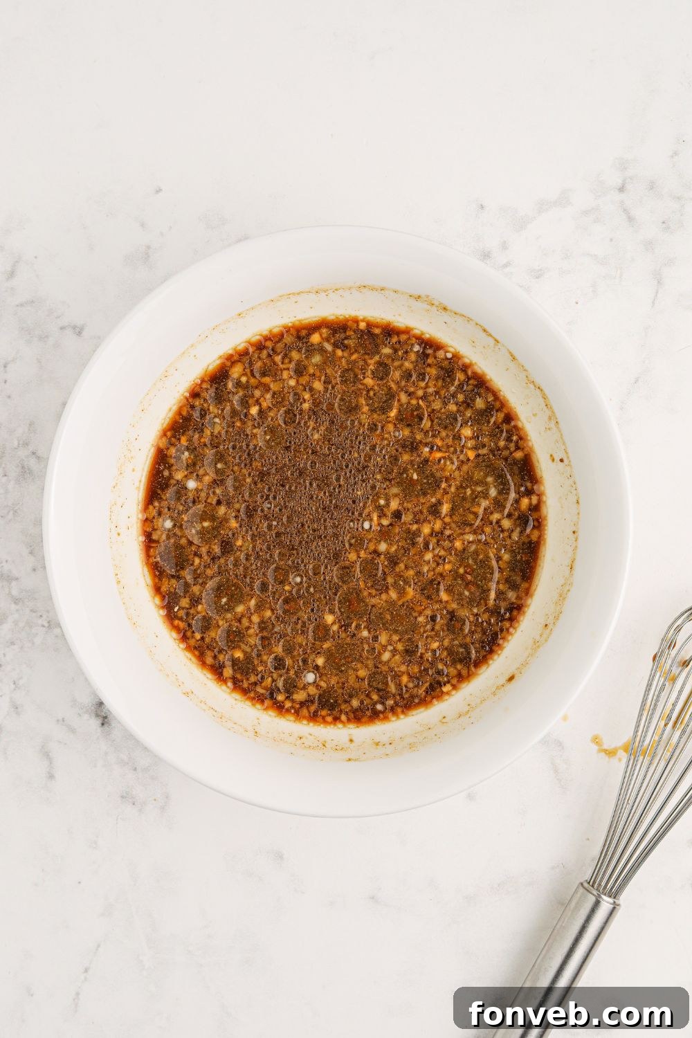 Irresistible Bourbon Chicken Skillet Quick Weeknight Win 7 bourbon sauce in a white bowl sitting on a marble counter