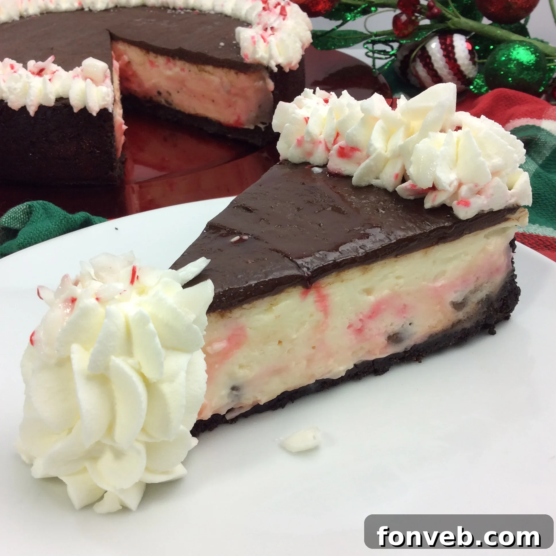 Decadent White Chocolate Peppermint Cheesecake 2 Beautifully garnished Candy Cane Cheesecake with crushed candy canes and chocolate drizzle