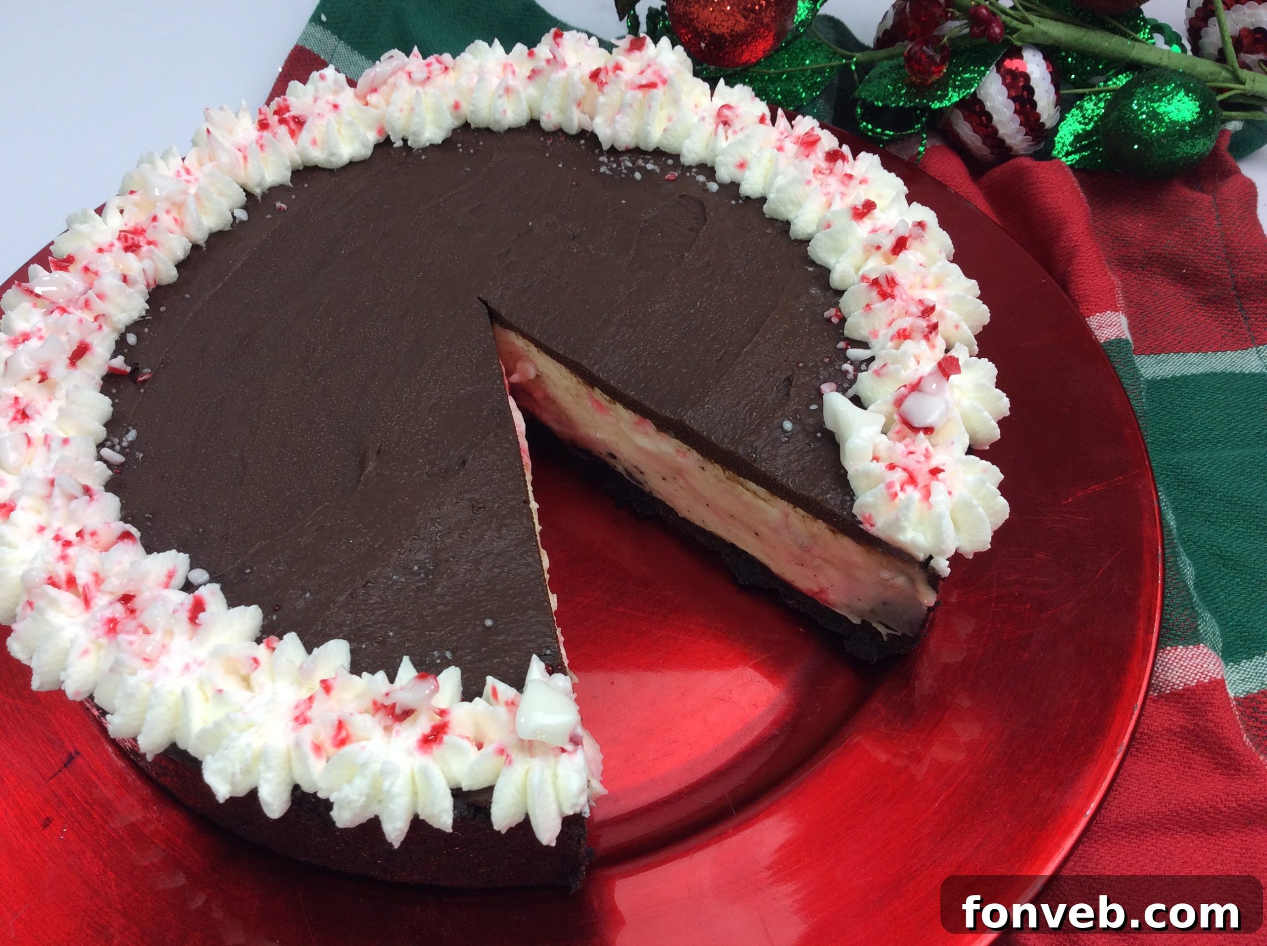 Decadent White Chocolate Peppermint Cheesecake 3 Close-up of a slice of Candy Cane Cheesecake, showing layers of crust, white chocolate filling, and toppings