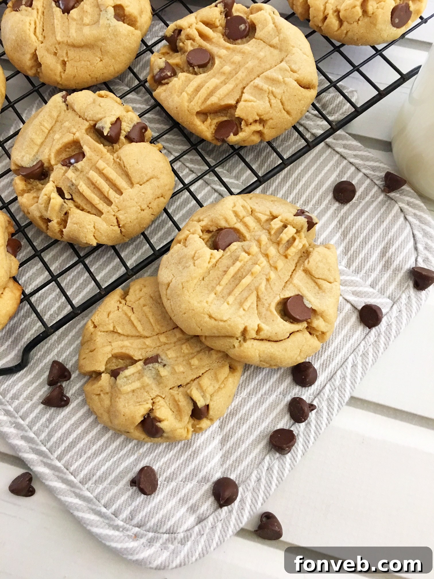 Toll House Velvety Soft Peanut Butter Cookies 8 Hand reaching for a super soft peanut butter cookie next to a glass of milk.