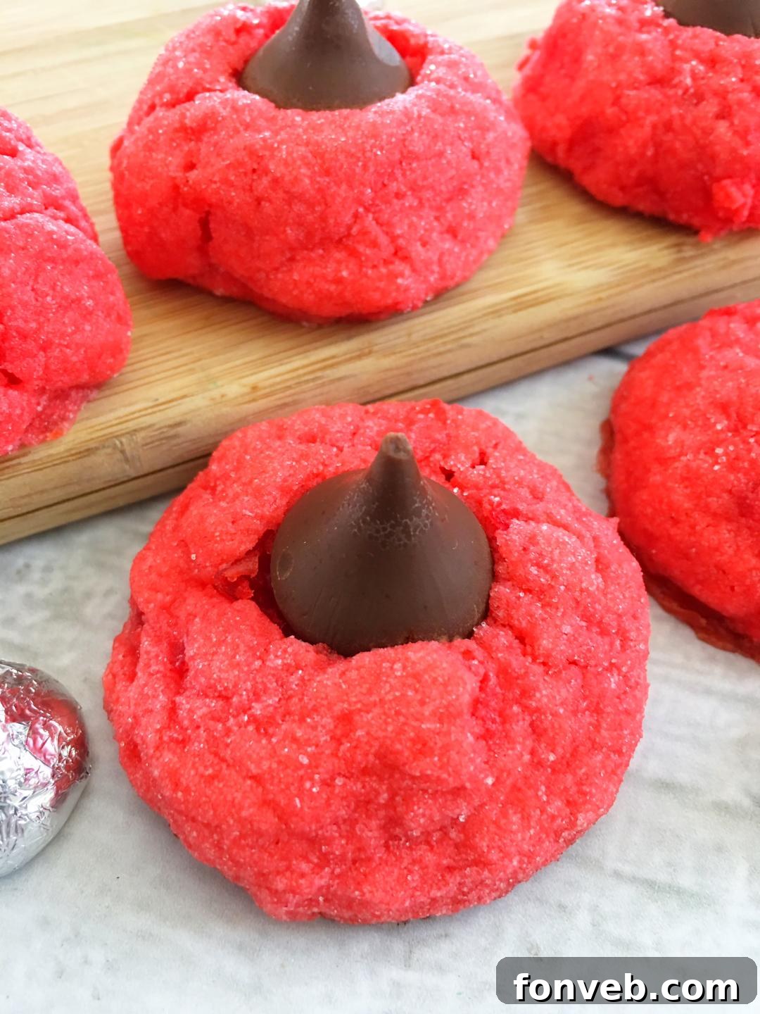 An overhead shot of several perfectly formed and baked Cherry Kiss Cookies, featuring their uniform size and appealing red hue.