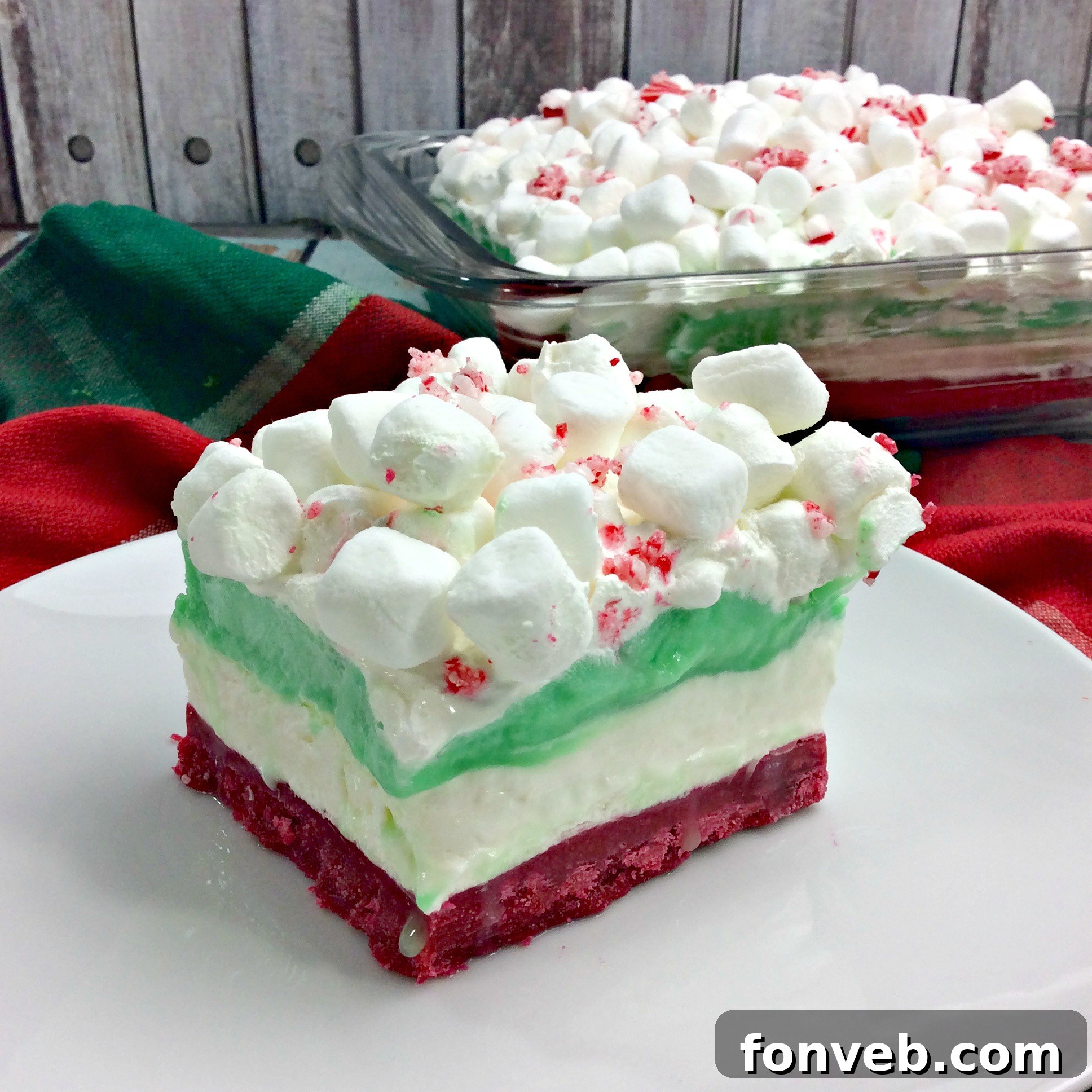 A serving of Christmas Cheesecake Lasagna on a plate, showing the impressive layered structure and festive garnish