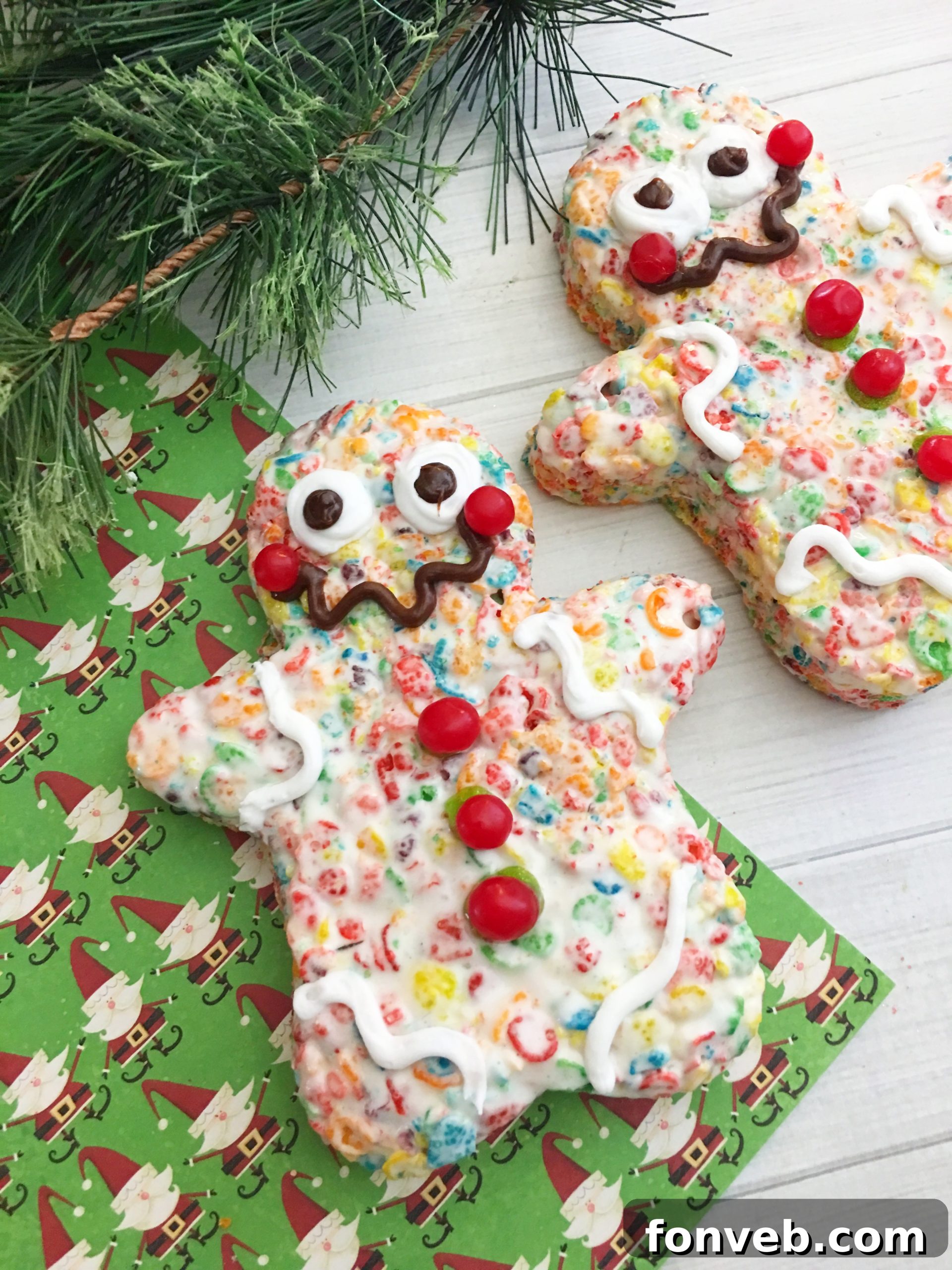 Adorable gingerbread-shaped Fruity Pebbles Krispy Treats, decorated with frosting and candies, on a white background.