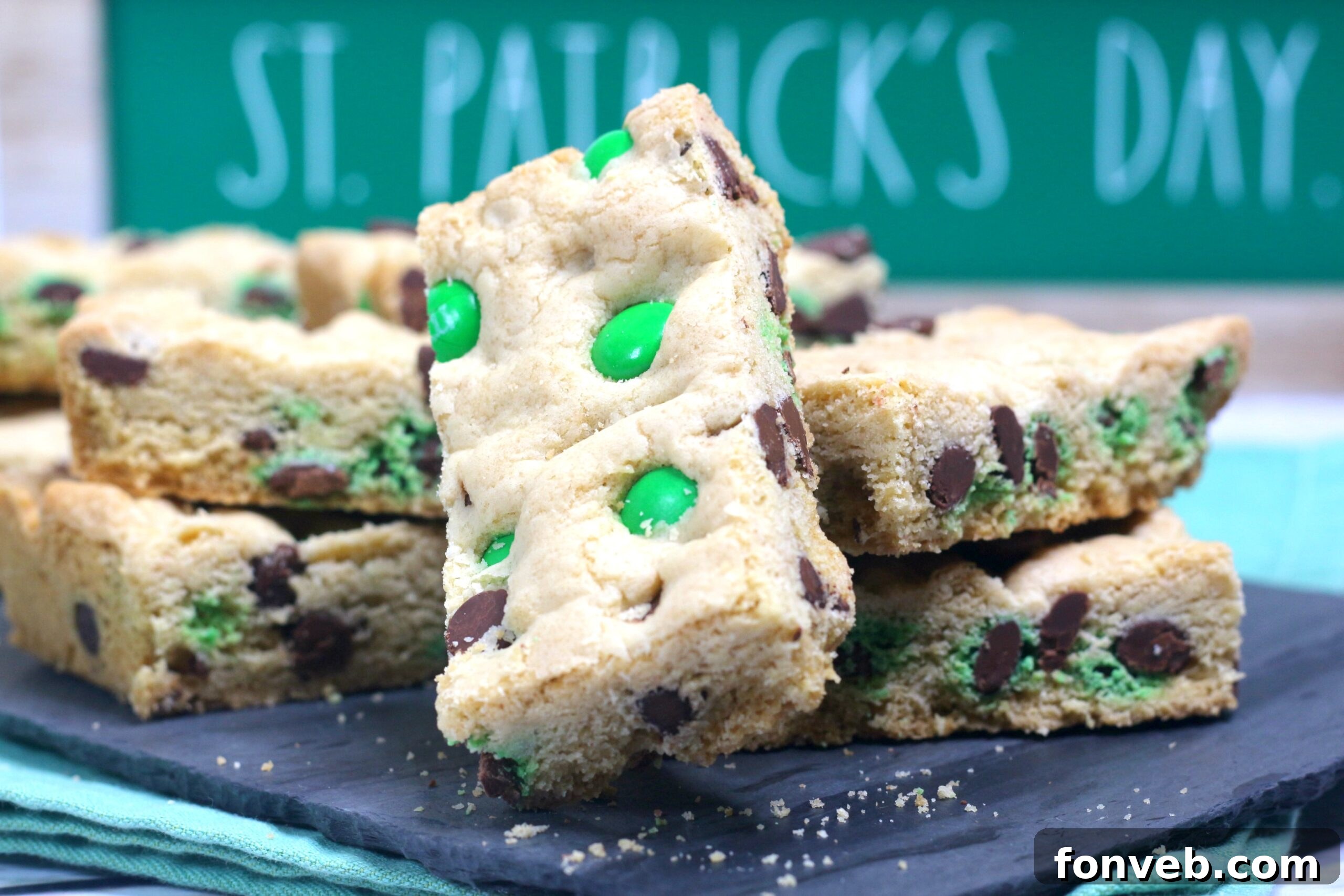Lucky Shamrock Chocolate Chip Cookie Bars 3 Saint Patrick's Day Chocolate Chip Cookie Bars displayed on a black serving tray with festive St. Patrick's Day decorations