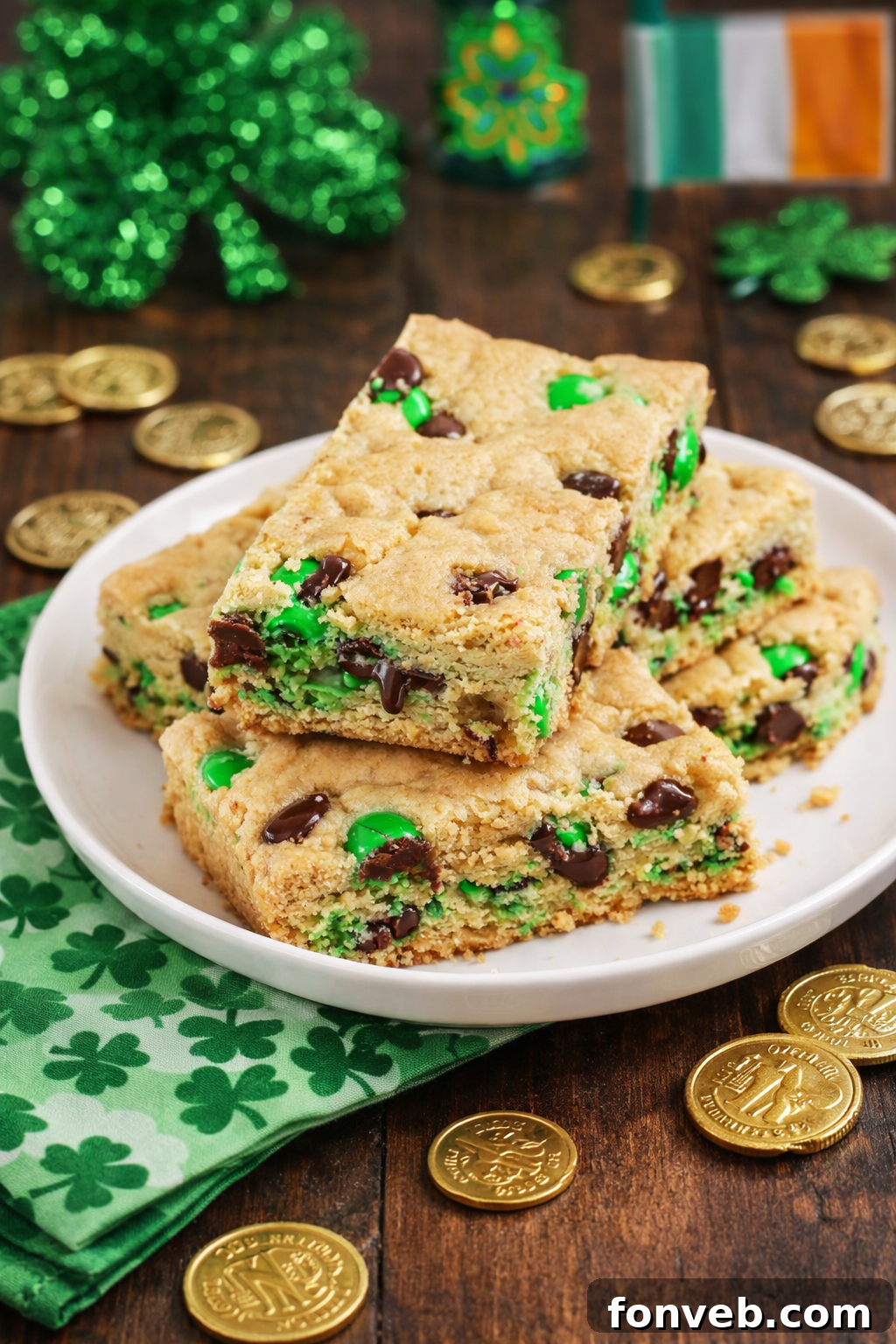 Lucky Shamrock Chocolate Chip Cookie Bars 5 Side view of Saint Patrick's Day Chocolate Chip Cookie Bars on a white plate with St. Patrick's Day decor