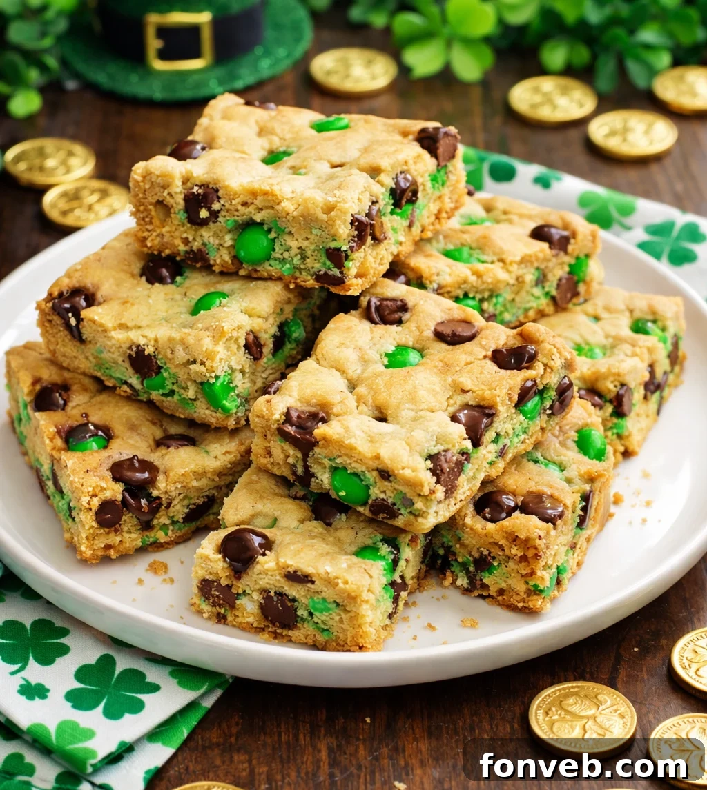 Lucky Shamrock Chocolate Chip Cookie Bars 8 Stacked image of Saint Patrick's Day Chocolate Chip Cookie Bars on a white plate with St. Patrick's Day decor
