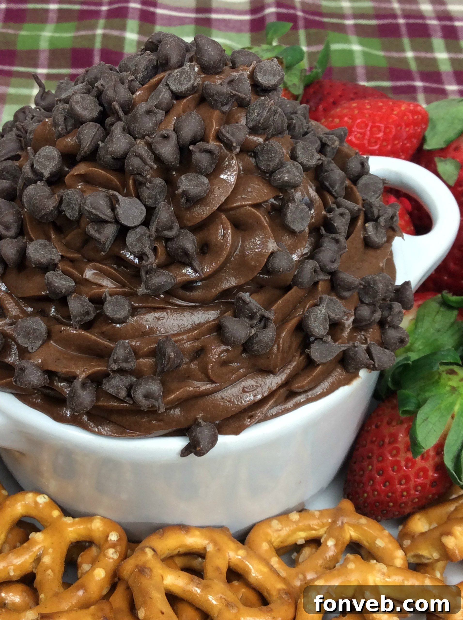 Close-up of a spoon scooping creamy, egg-free Brownie Batter Dip topped with mini chocolate chips
