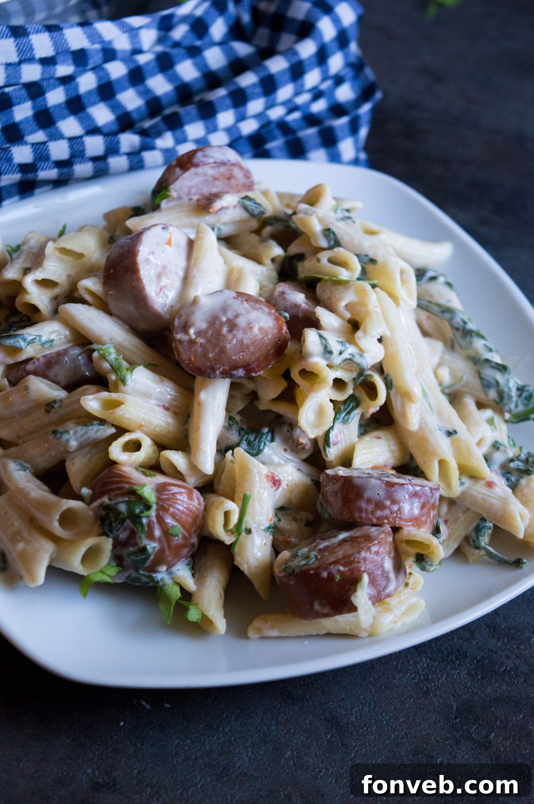 Luscious Garlic Mozzarella Pasta with Spinach and Sausage 4 A serving of Creamy Mozzarella Pasta with Spinach and Sausage, ready to be enjoyed