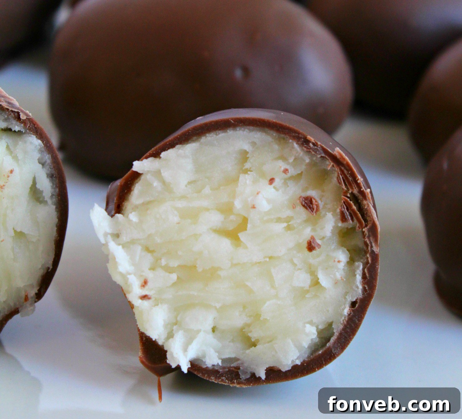 Various ingredients laid out for making coconut cream eggs, including cream cheese, butter, powdered sugar, shredded coconut, and chocolate chips