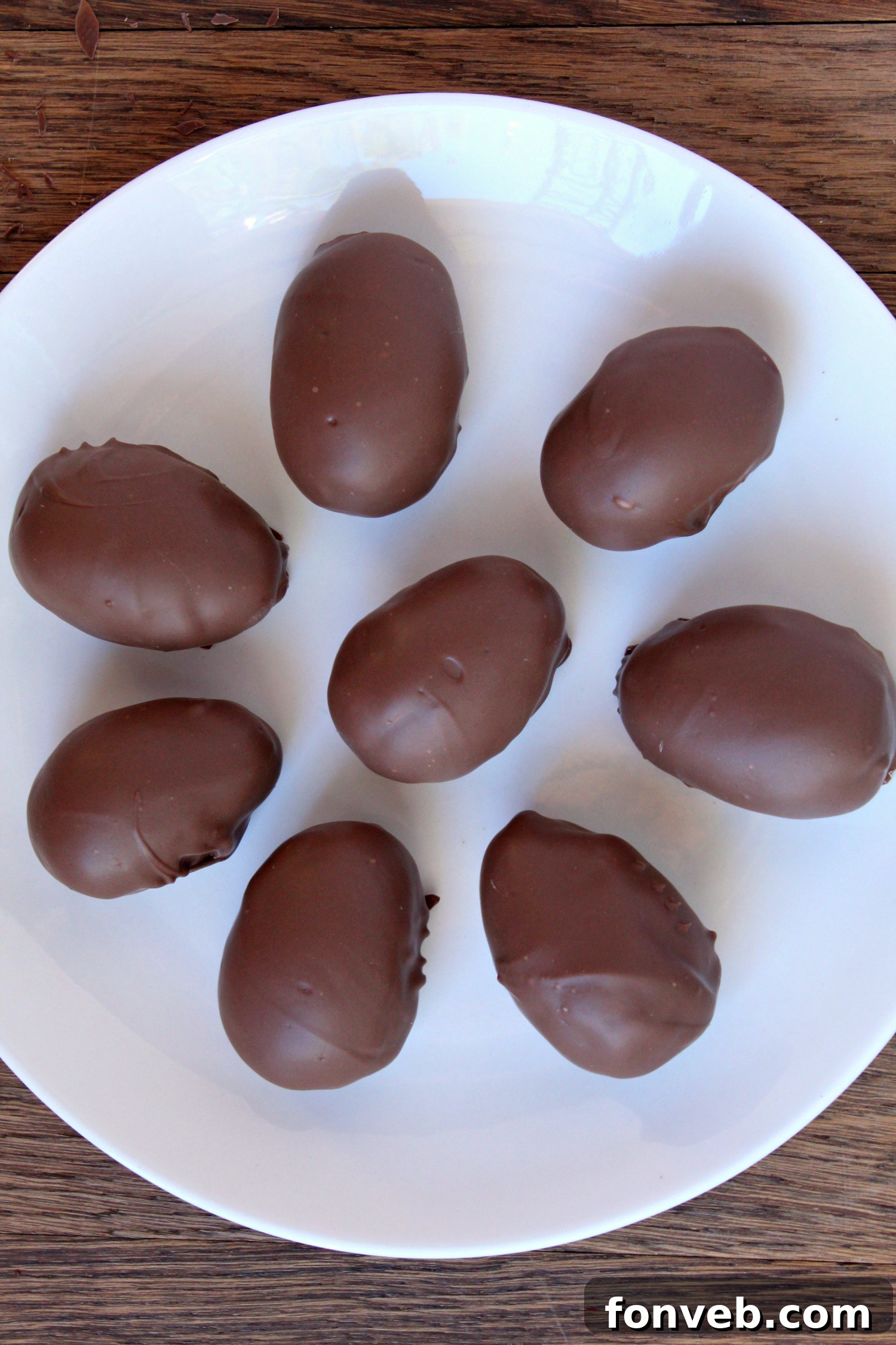 A finished homemade coconut cream egg, perfectly dipped in chocolate, ready to enjoy