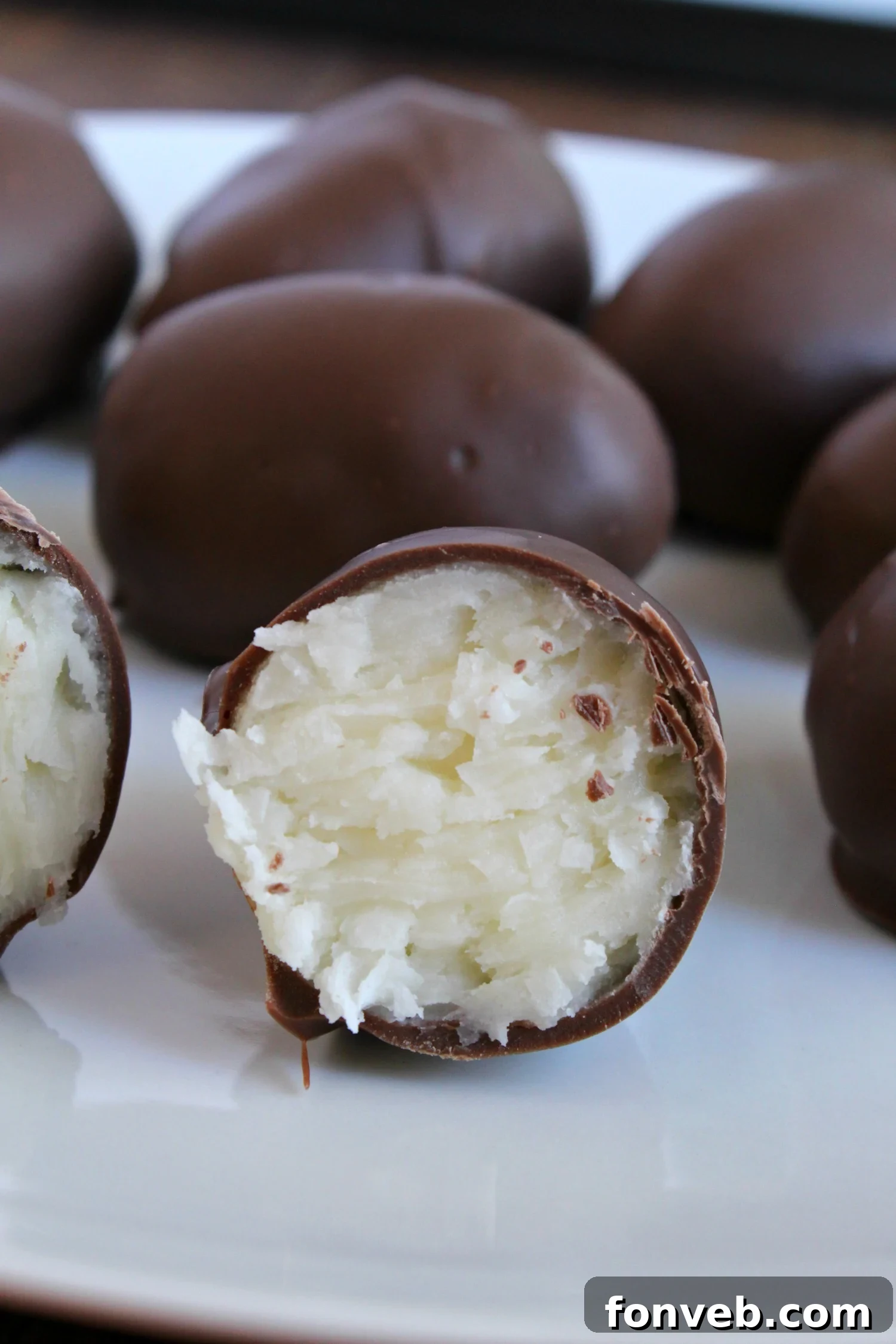 A close-up shot of a single, perfectly crafted homemade coconut cream egg, highlighting its smooth chocolate coating and potential for decorative elements