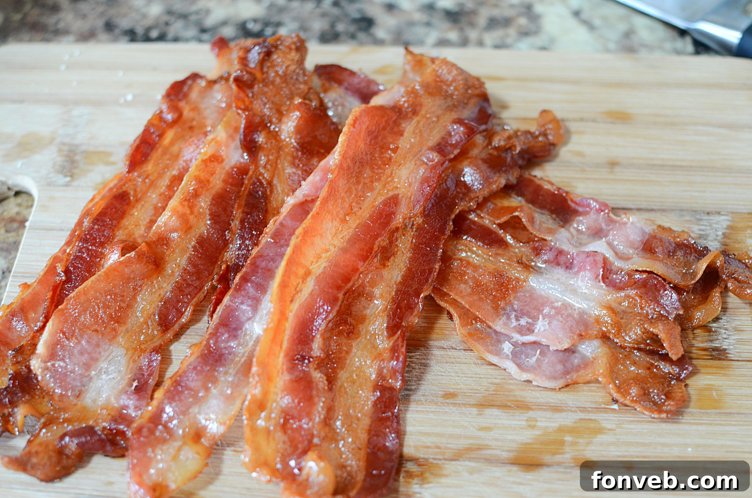 Cooked bacon slices cooling on a plate, ready to be enjoyed