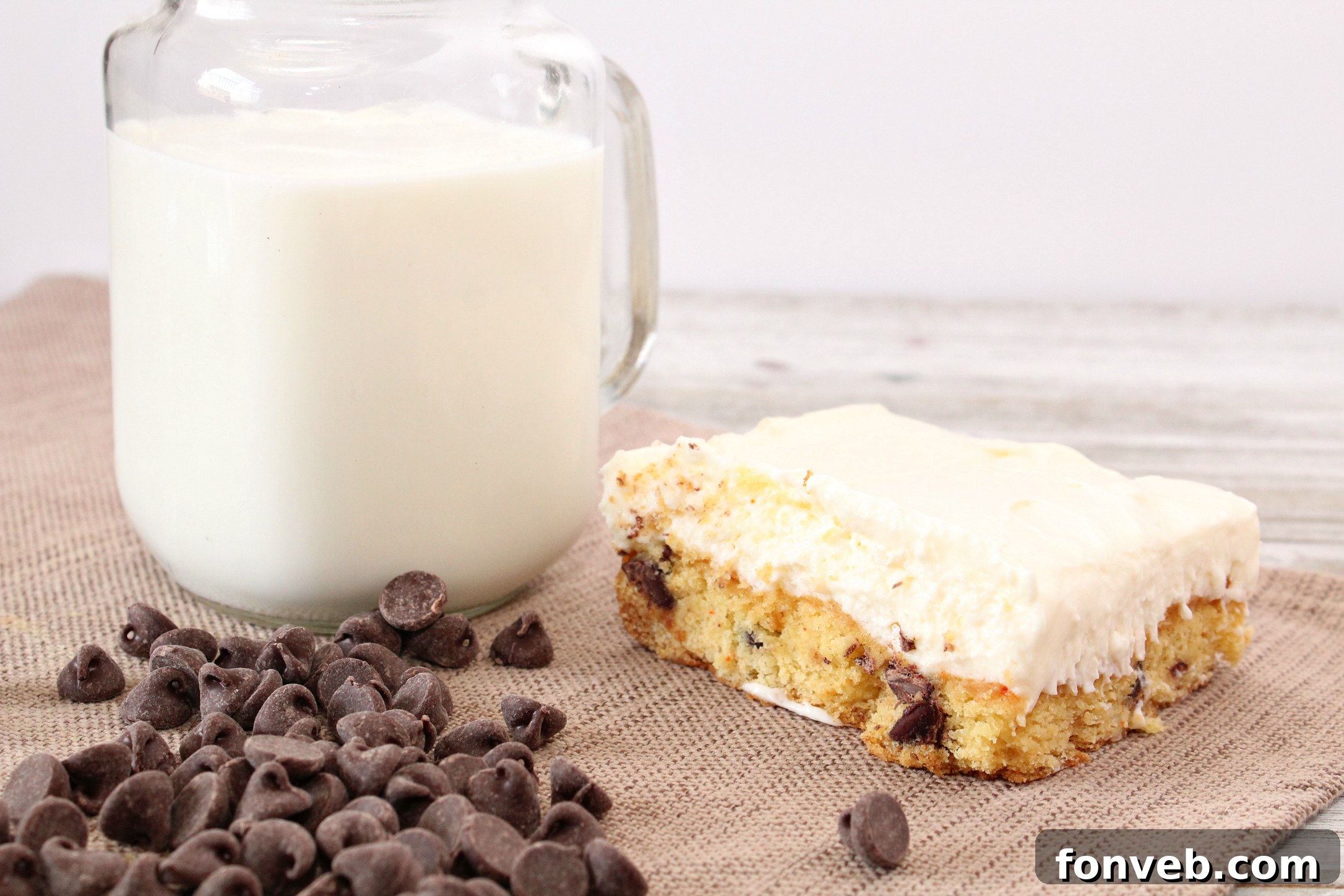 The golden-brown, baked cookie base for the Toll House Chocolate Chip Cheesecake Bars, cooling in a 9x13 inch pan before the addition of the creamy topping.
