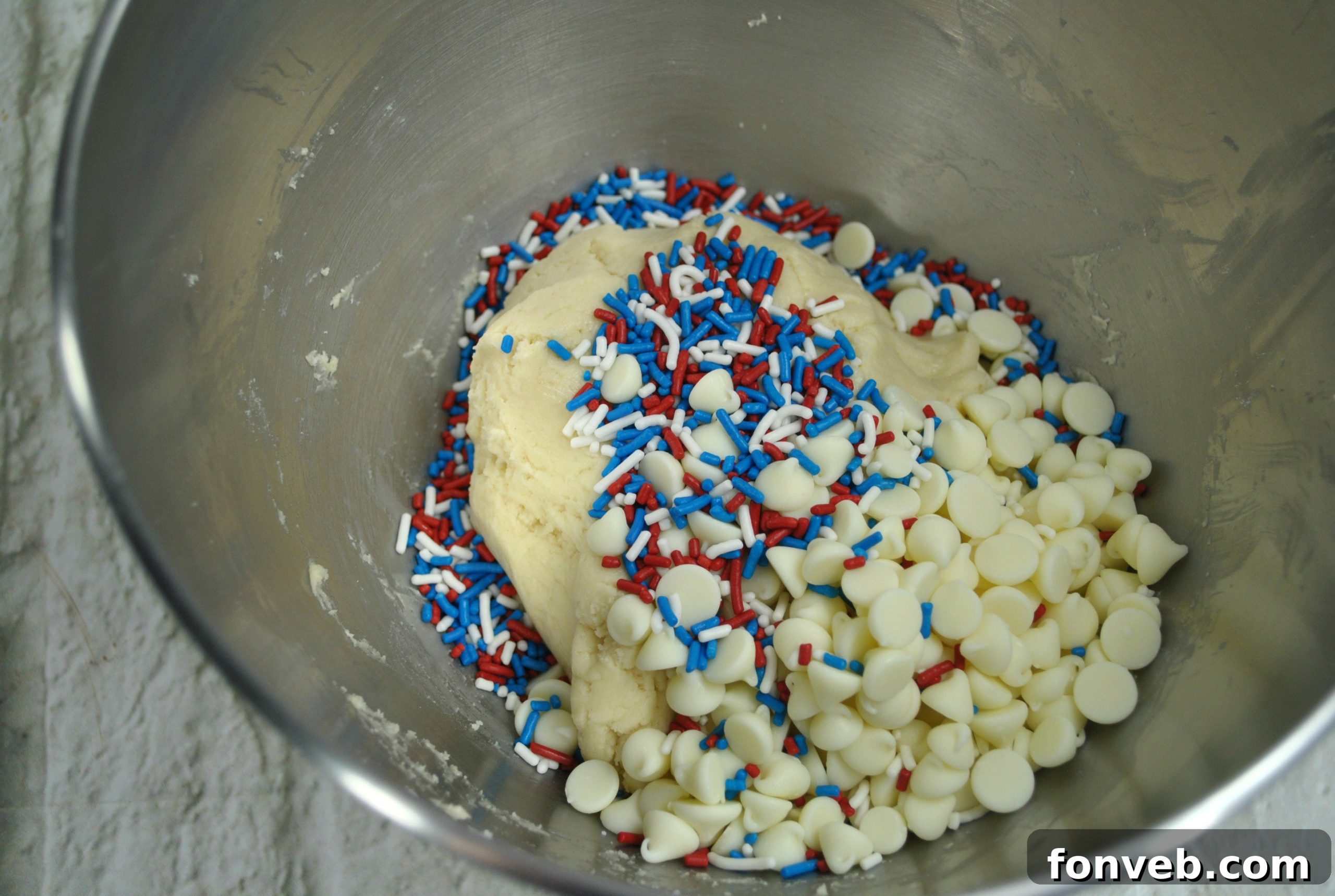 Close-up shot of soft and chewy White Chocolate Firework Cookies arranged on a baking sheet, highlighting their texture and colorful sprinkles.