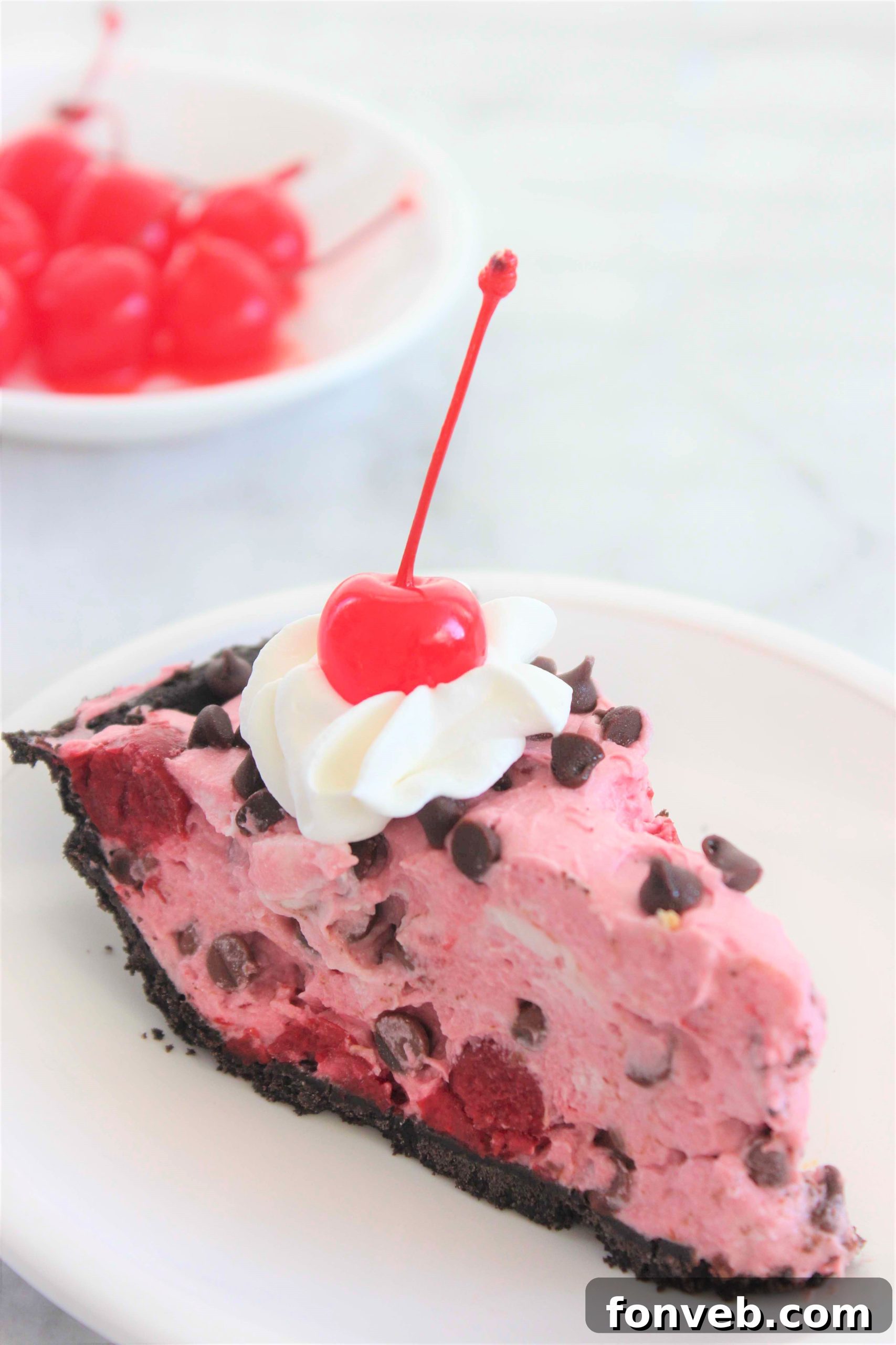 Slice of No-Bake Cherry Chocolate Chip Creamsicle Pie with a creamy cherry filling and chocolate chips