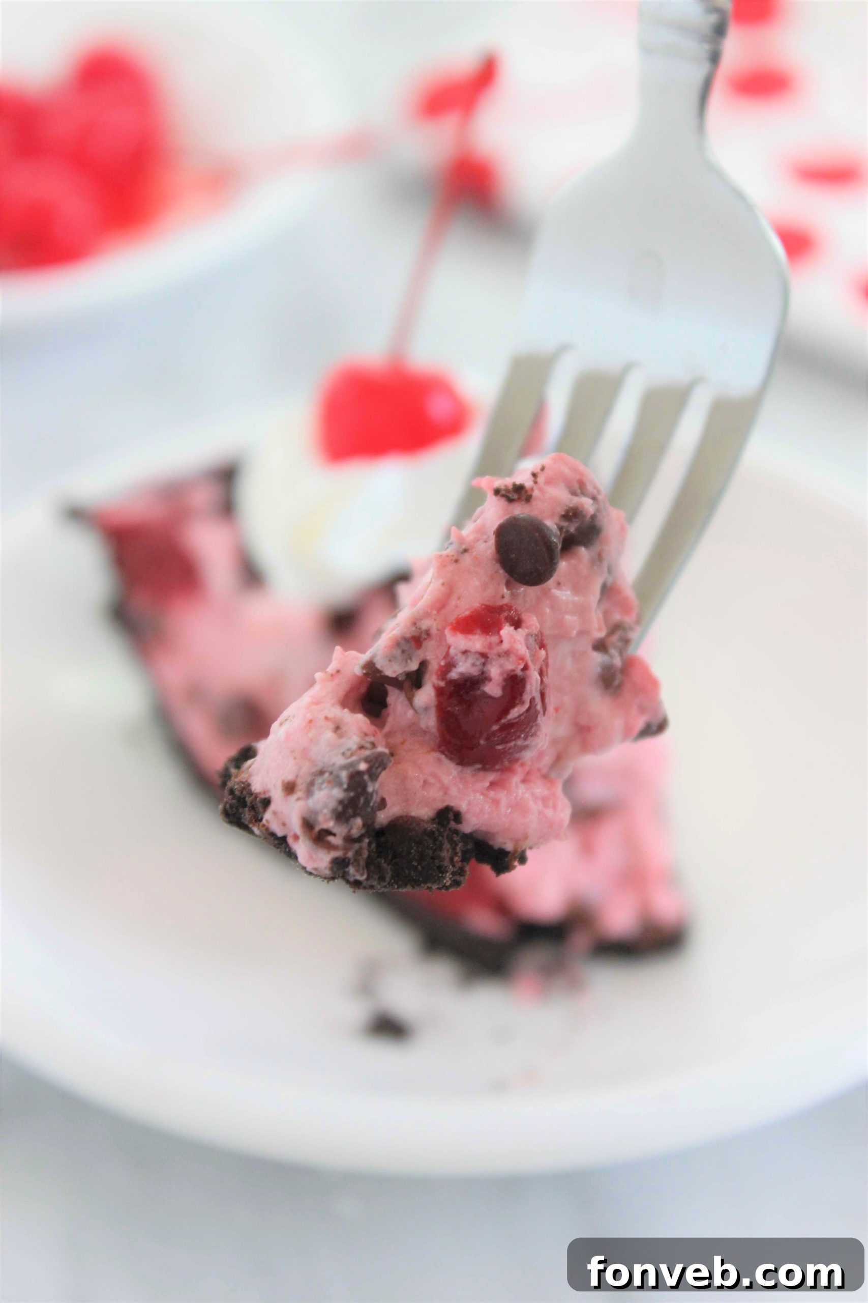 A beautifully presented slice of Cherry Chocolate Chip Creamsicle Pie, showing layers and garnishes