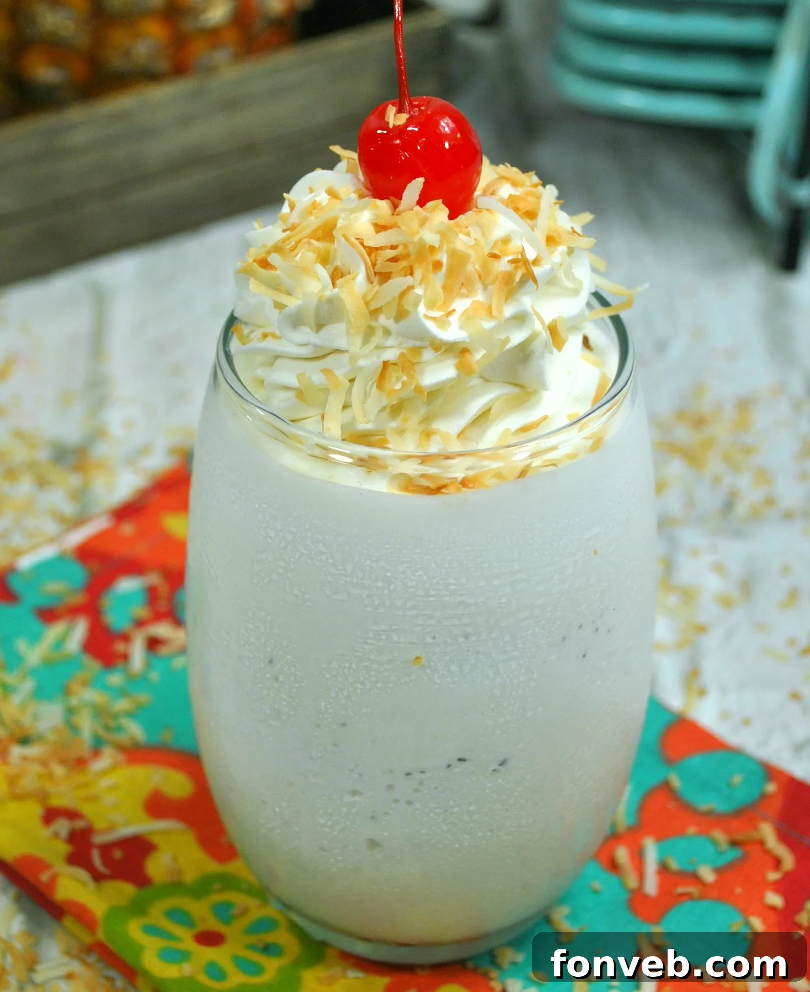 Refreshing Pina Colada cocktail in a tall glass, garnished with pineapple slice and maraschino cherry