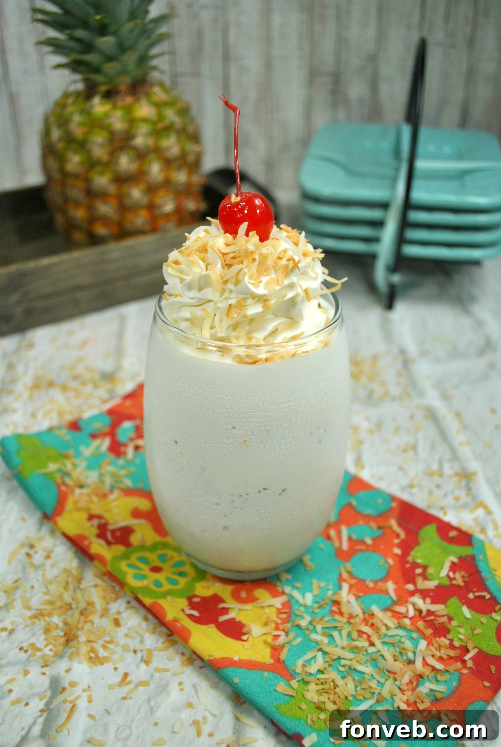 Close-up of a frothy, perfectly blended Pina Colada cocktail with a maraschino cherry on top