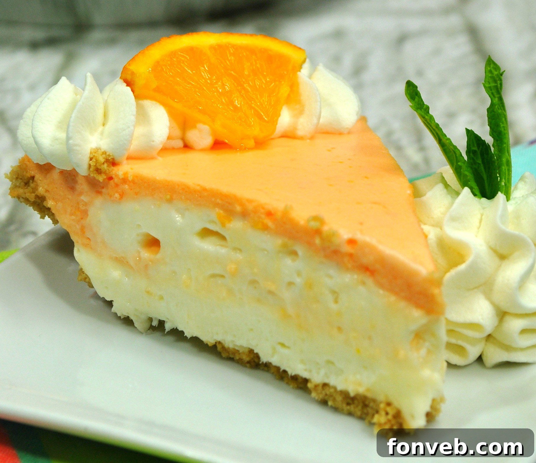 Delicious slice of Orange Creamsicle Cheesecake on a white plate