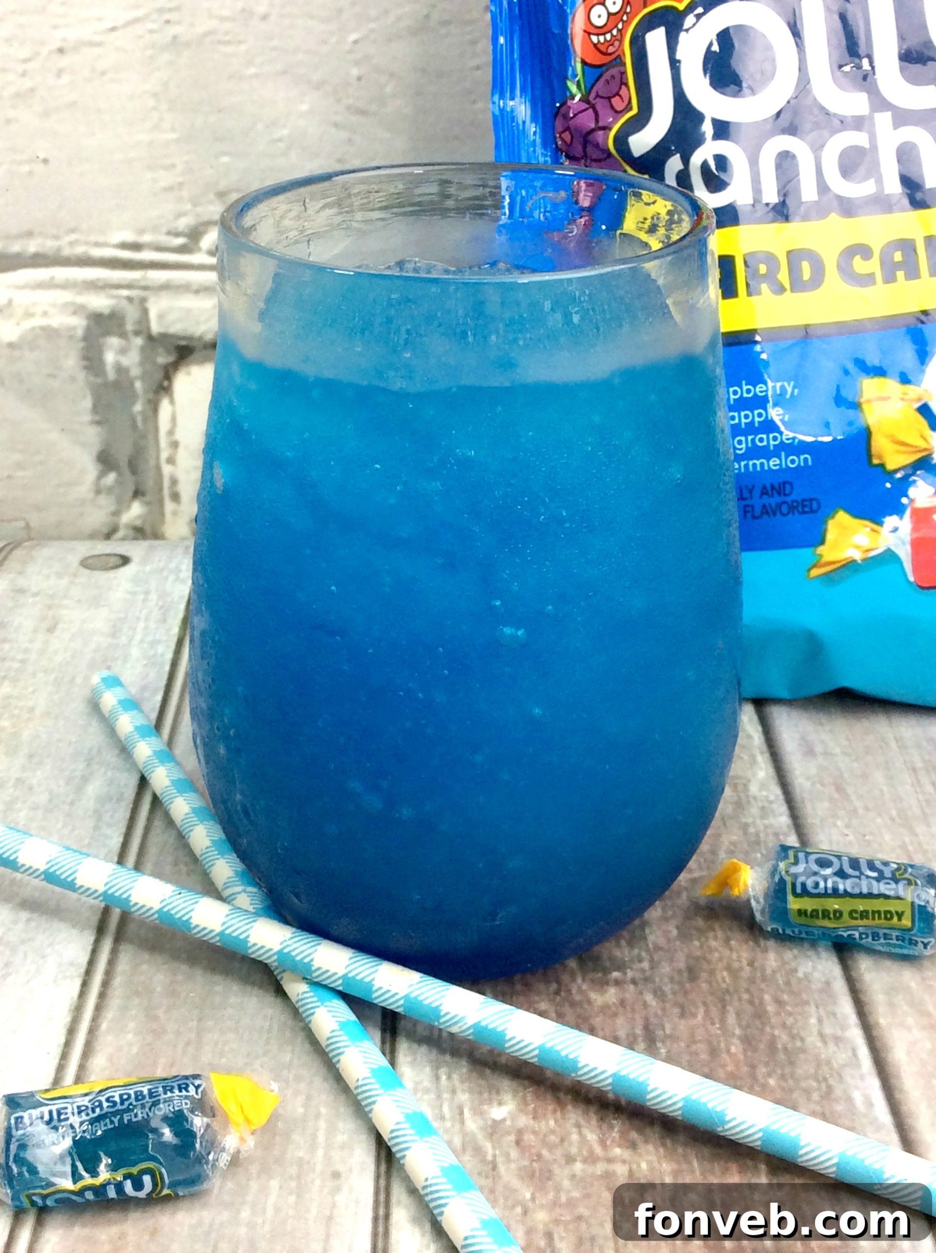 Delicious Blue Raspberry Jolly Rancher Cocktail in a glass with candy garnish