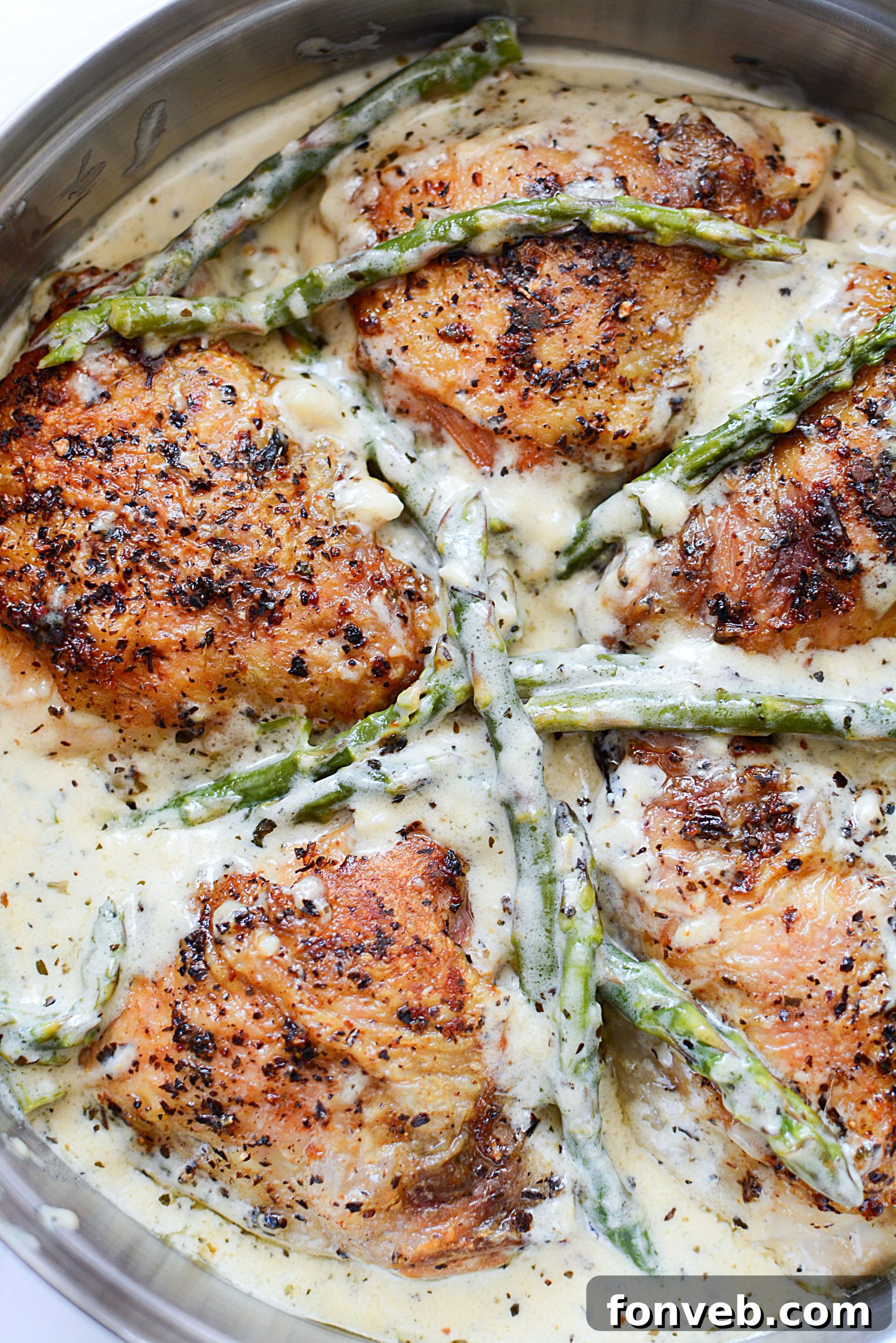 A final close-up of the cooked chicken and asparagus, highlighting the tender pieces coated in creamy sauce