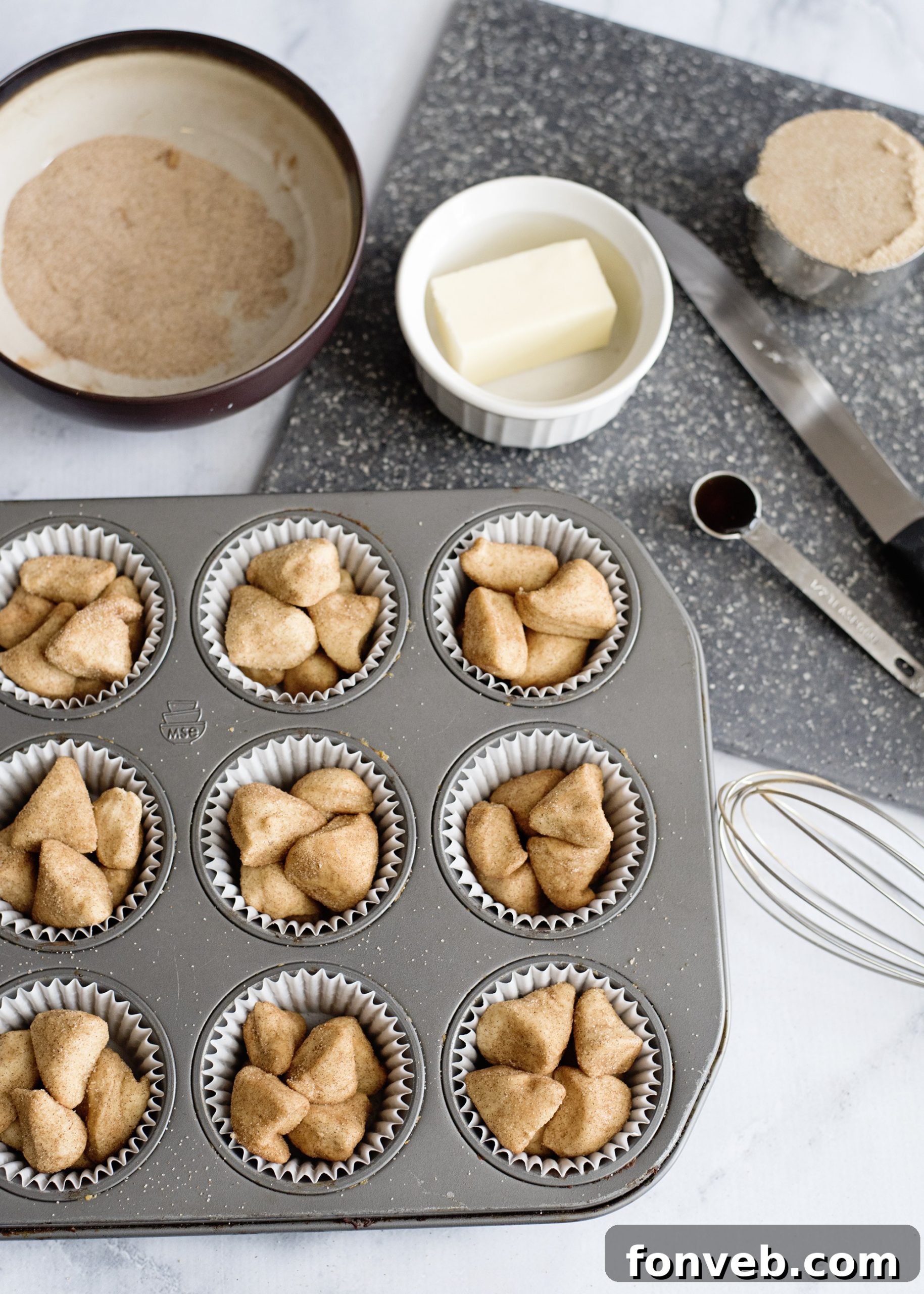 Irresistible Snickerdoodle Pull-Apart Muffins 4 Dough pieces being tossed in a bowl with cinnamon sugar mixture, preparing them for the muffins.