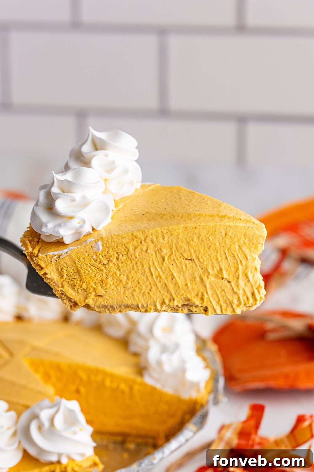 pumpkin pie cheesecake with slice on spatula