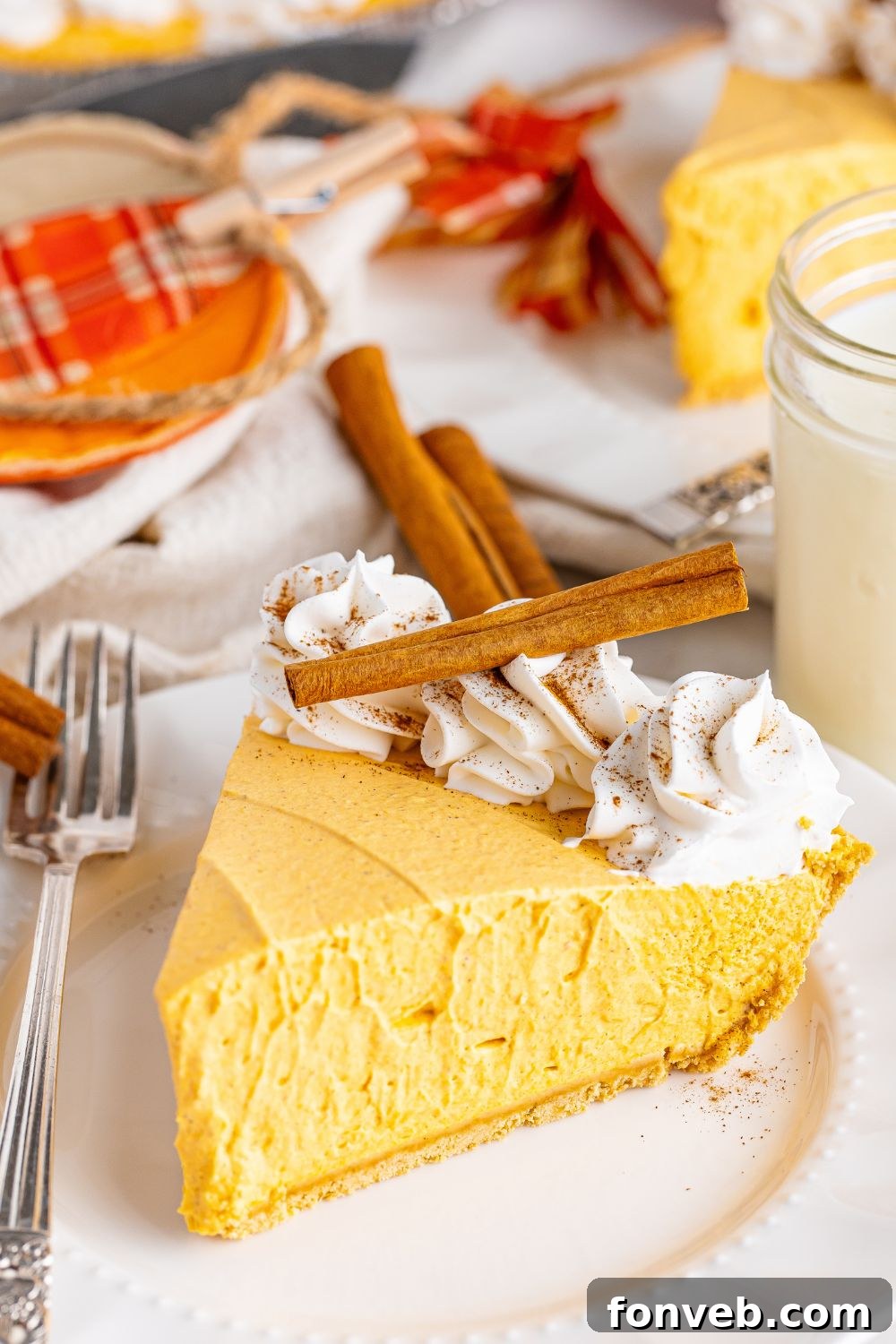 pumpkin cheesecake on plate with cinnamon stucks on top