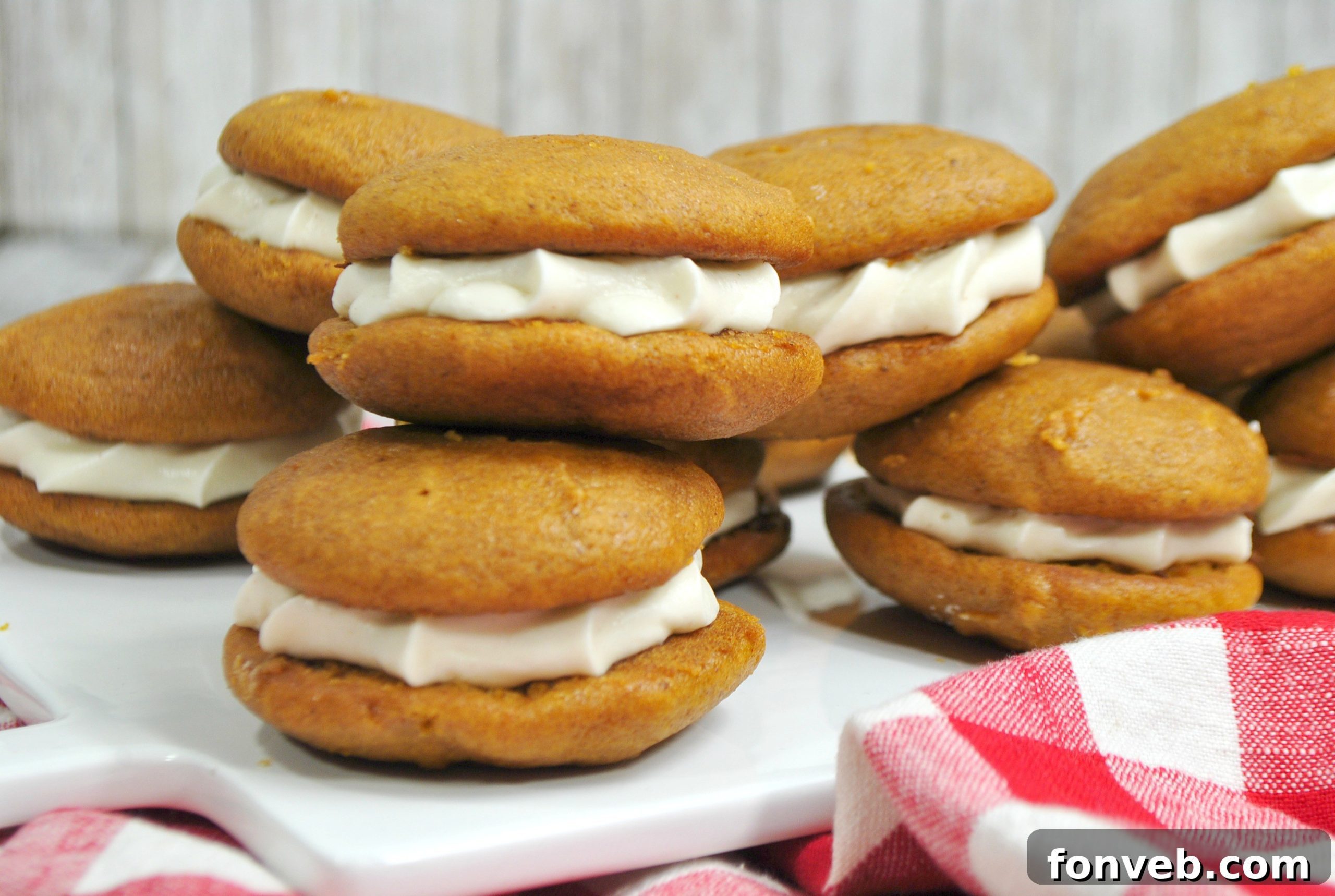 Stacked pumpkin whoopie pies on a plate, ready to be served