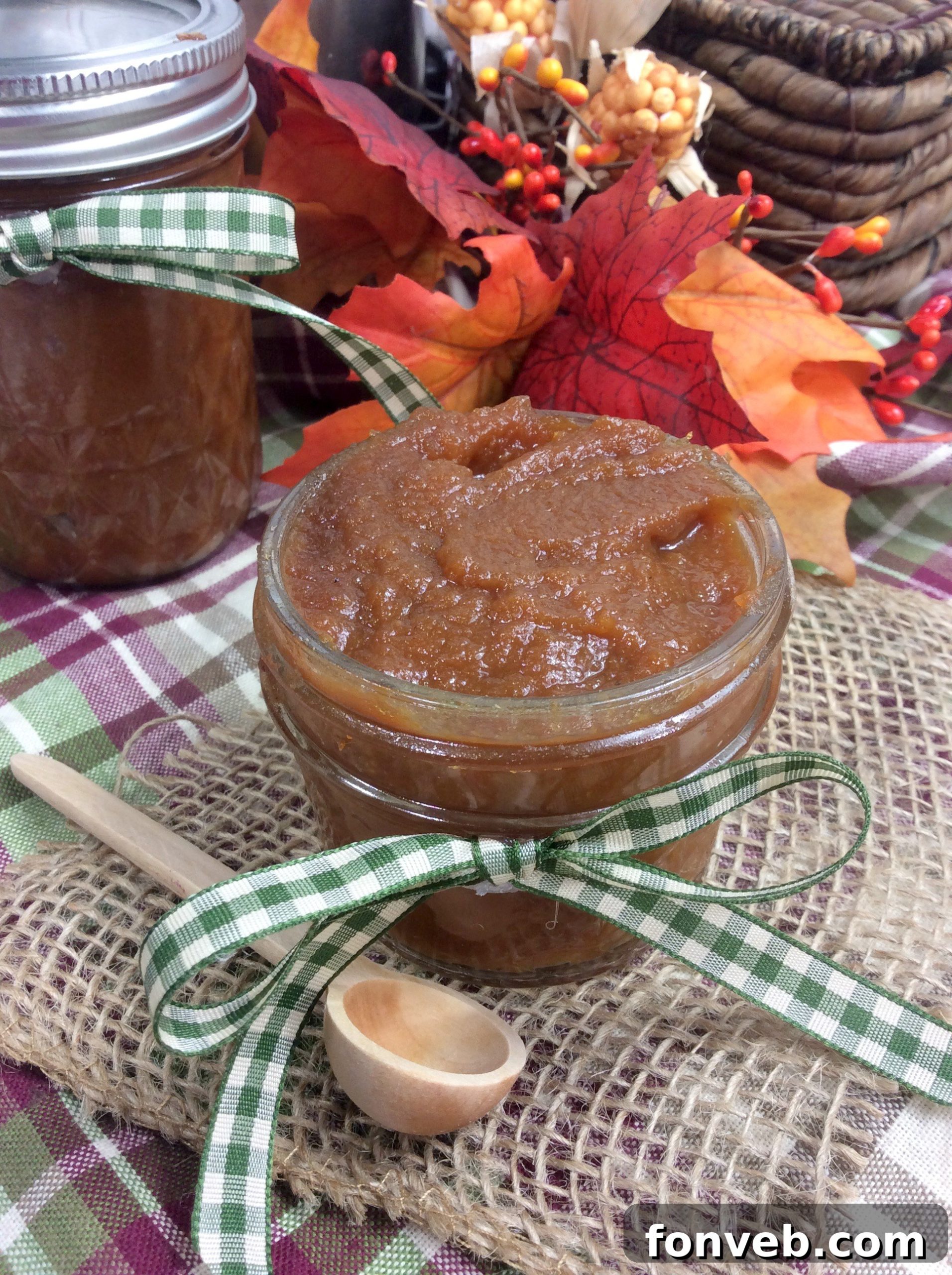 Spiced Instant Pot Pumpkin Butter 6 A jar of smooth pumpkin butter with a spoon resting in it
