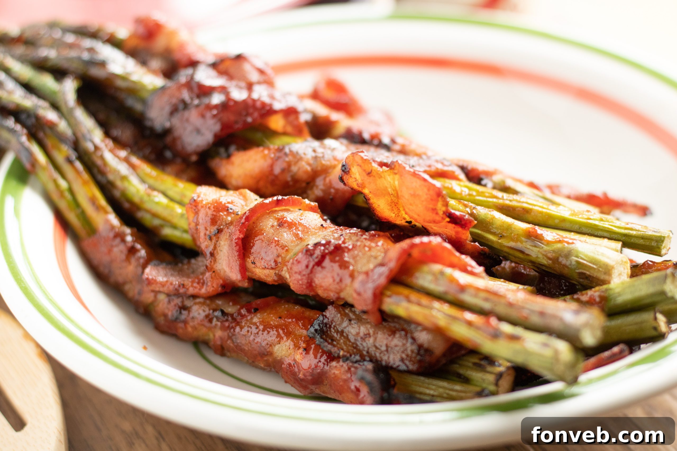 Close-up of golden brown bacon wrapped asparagus cooking on a baking sheet