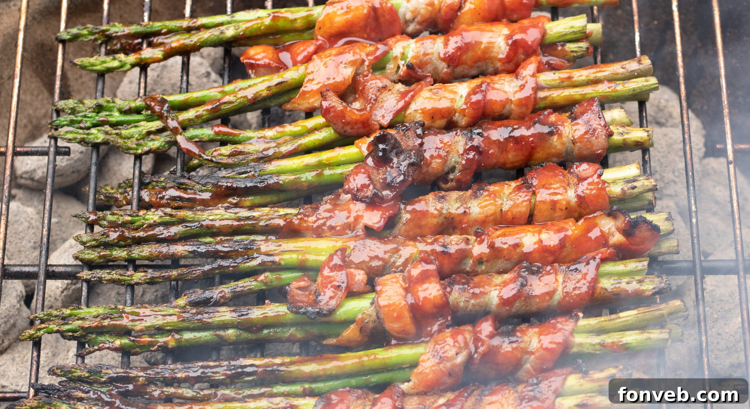 Bacon wrapped asparagus cooking on a grill with visible flames