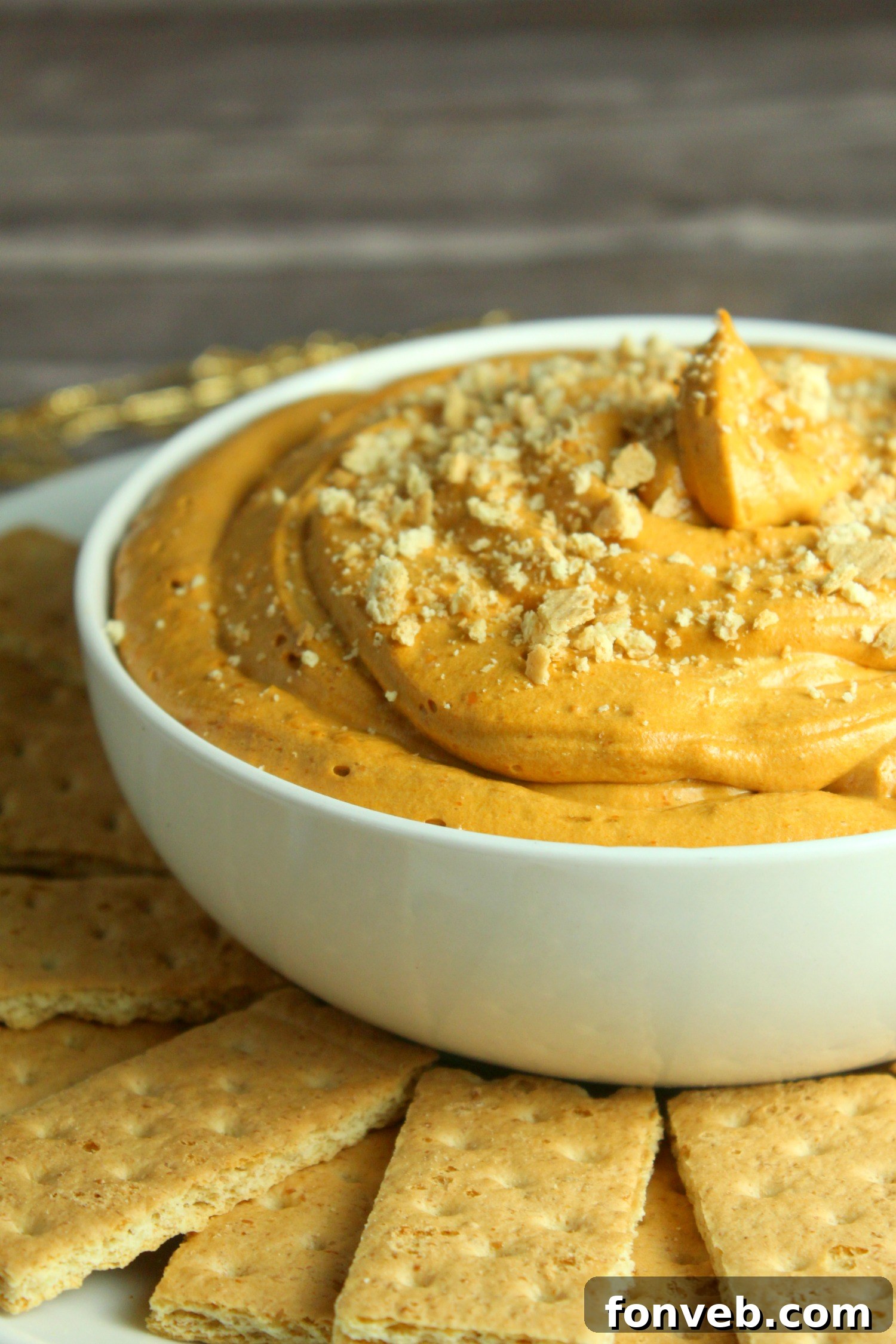 The creamy pumpkin pie cheesecake dip served elegantly in a festive pumpkin-shaped bowl, ready to be enjoyed as a centerpiece.
