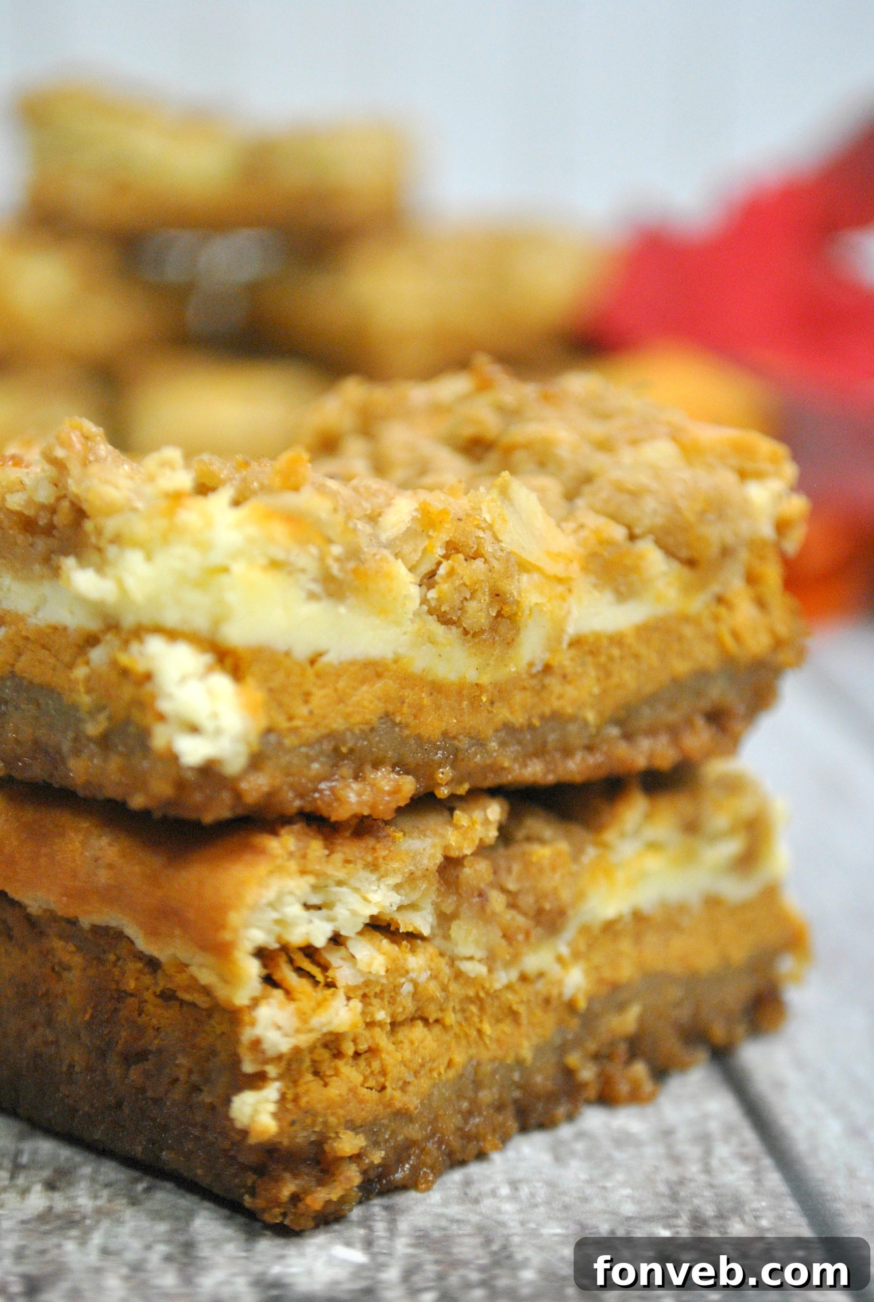 Harvest Pumpkin Crumble Cheesecake Squares 8 A single pumpkin cheesecake bar on a simple white plate, highlighting the rich texture of the streusel and the inviting layers of the bar.