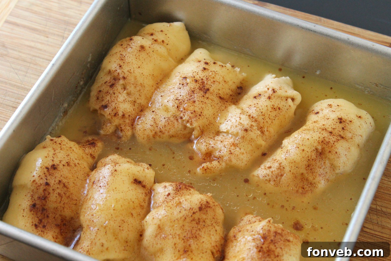Peachy Keen Dumplings 5 A single, perfectly golden peach dumpling on a white plate, highlighting its flaky crust.