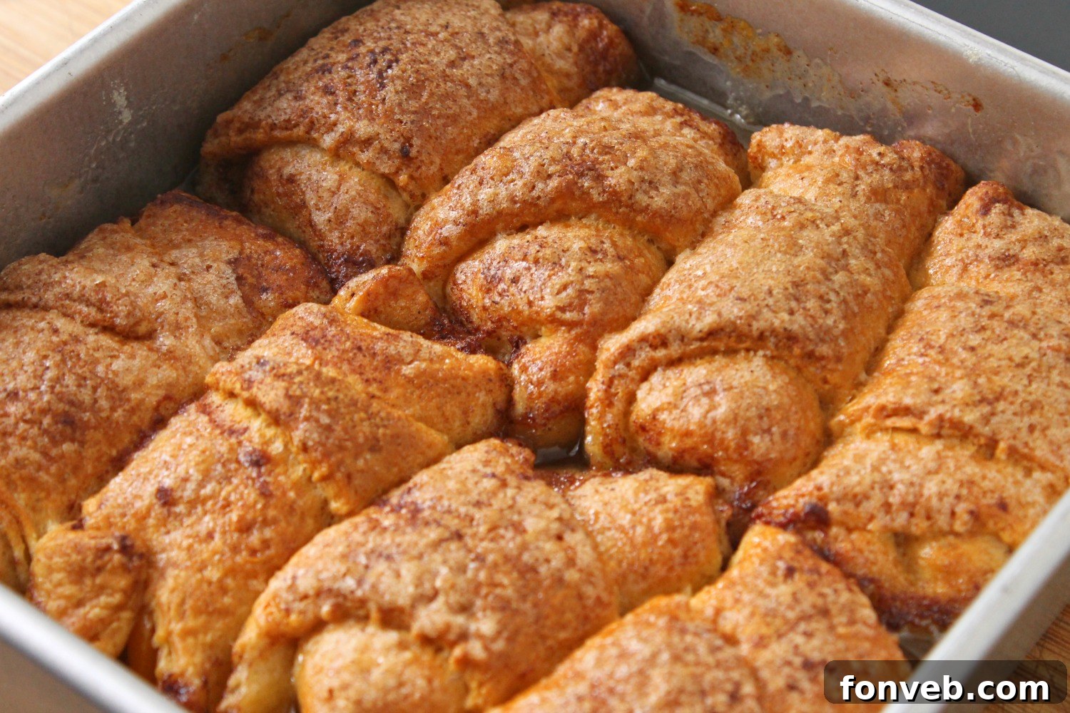 Peachy Keen Dumplings 6 A close-up of a peach dumpling served in a bowl, topped with a generous dollop of whipped cream and a sprinkle of cinnamon.
