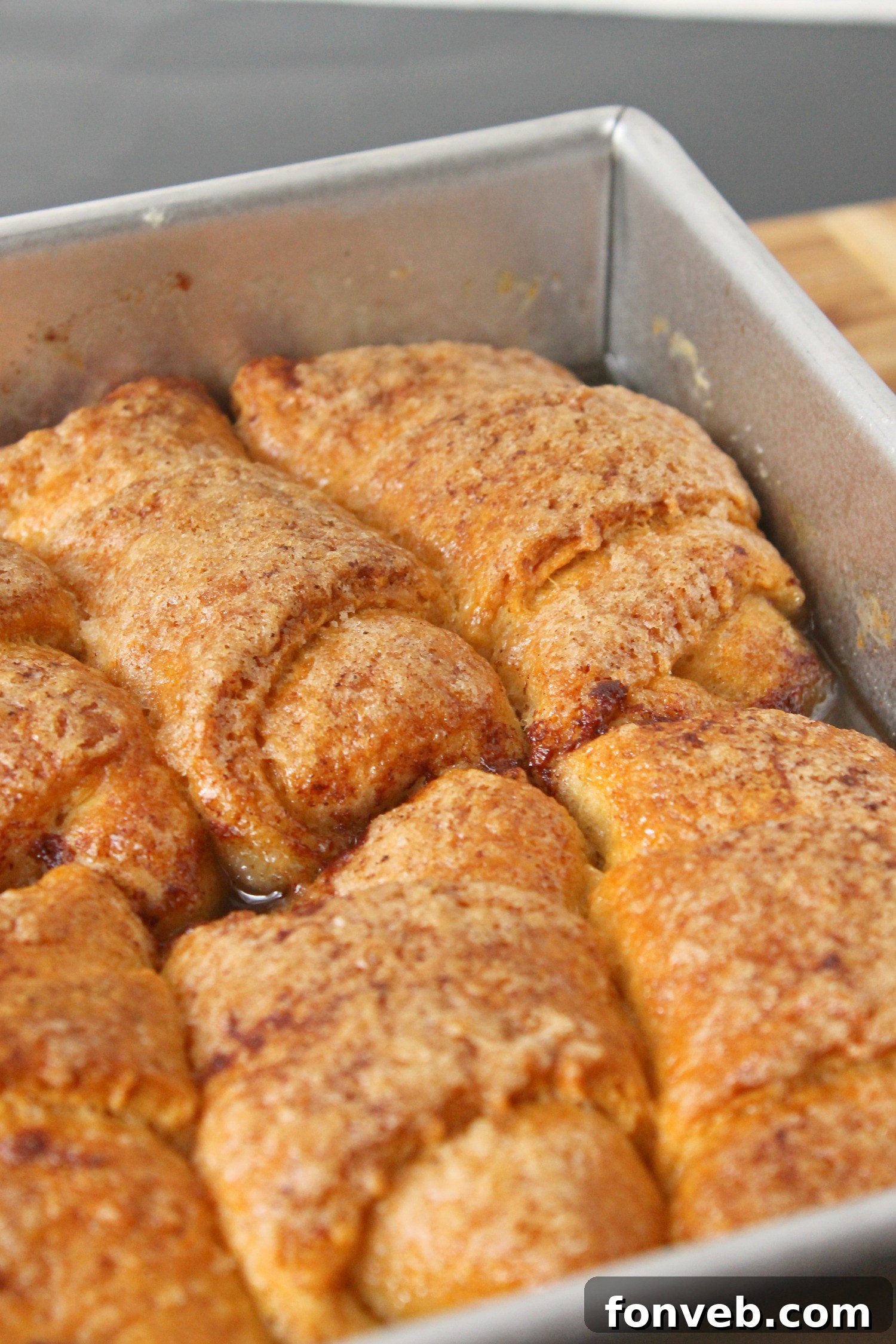Peachy Keen Dumplings 7 A top-down view of peach dumplings in a baking dish, with extra sauce and cinnamon.