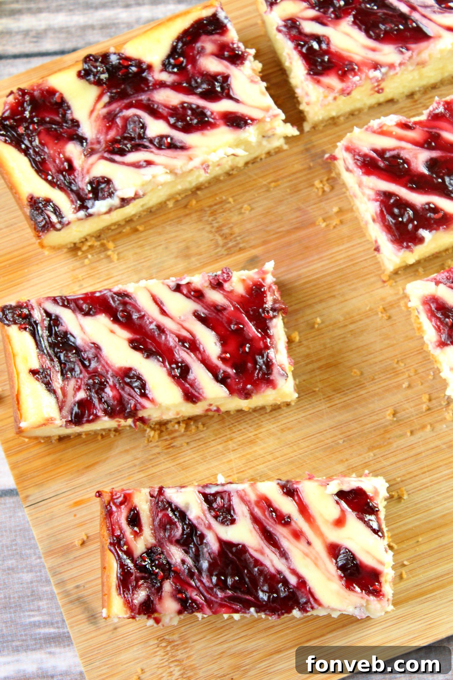 A single, perfectly cut lemon raspberry cheesecake bar resting on a pristine white plate, with the smooth cheesecake layer, a hint of zest, and bold raspberry swirls visible.