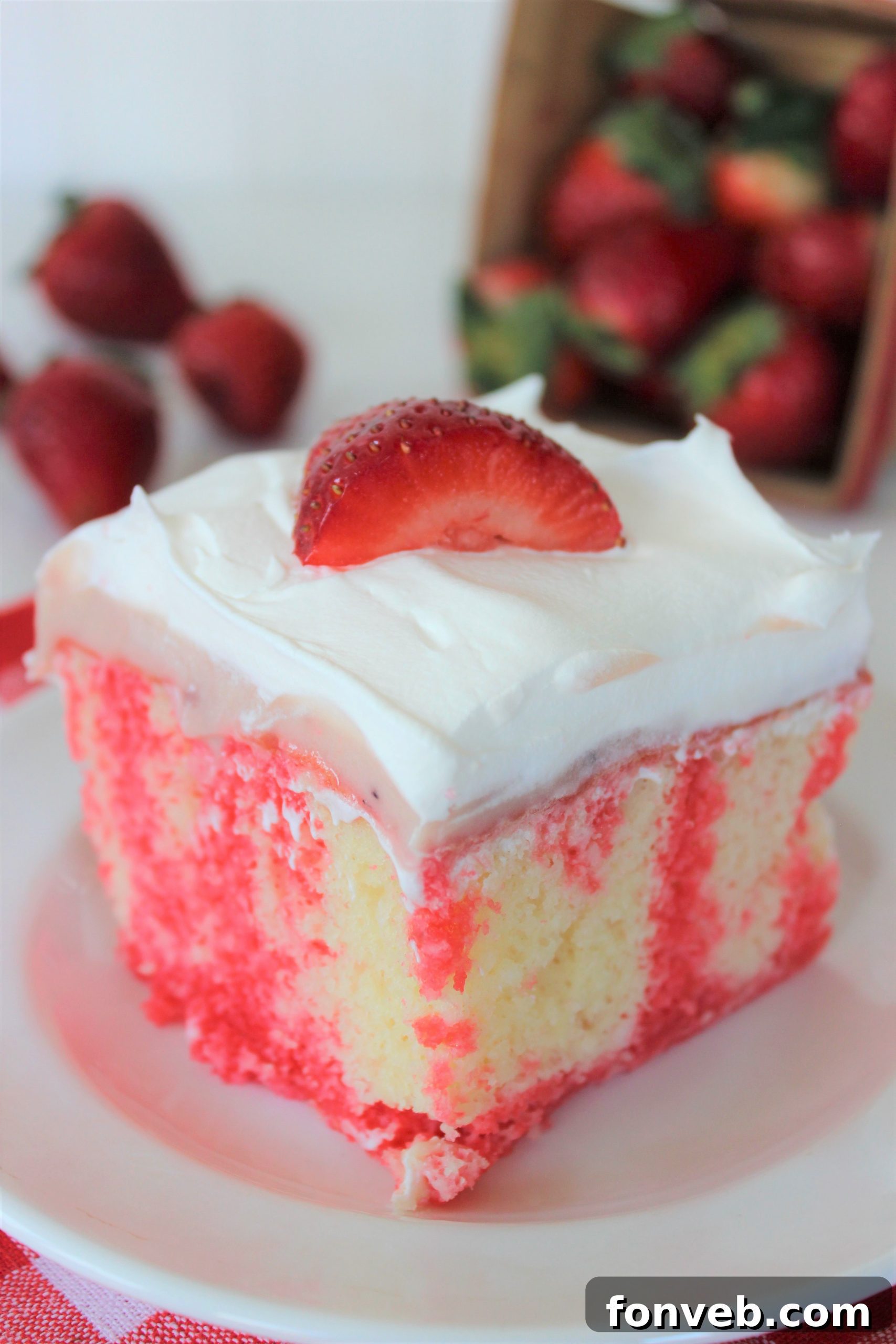 Luscious Strawberry Cheesecake Poke Cake 4 Strawberry Cheesecake Poke Cake cooling on a rack after jello has been poured