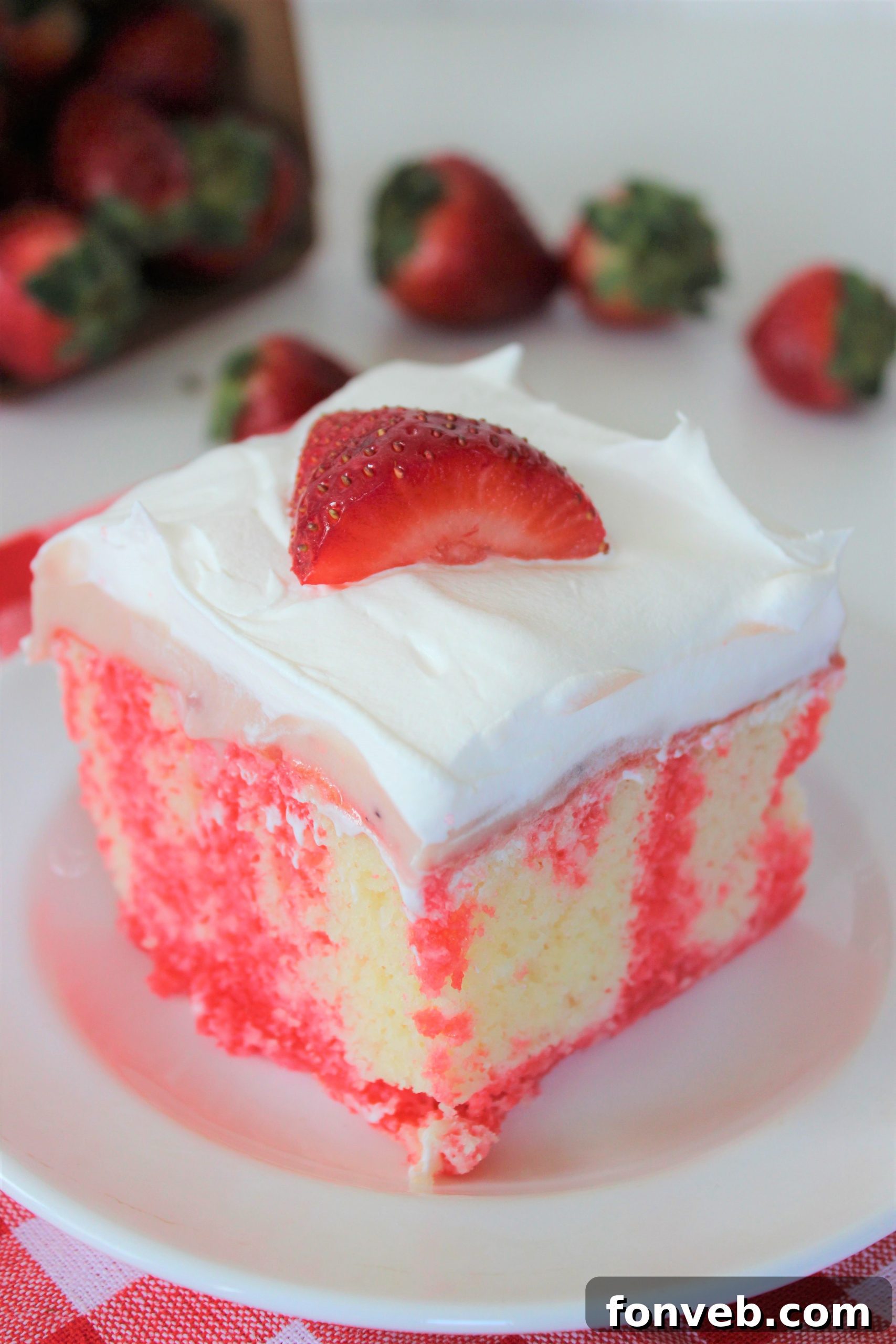Luscious Strawberry Cheesecake Poke Cake 5 Served slice of Strawberry Cheesecake Poke Cake on a plate, garnished with fresh berries