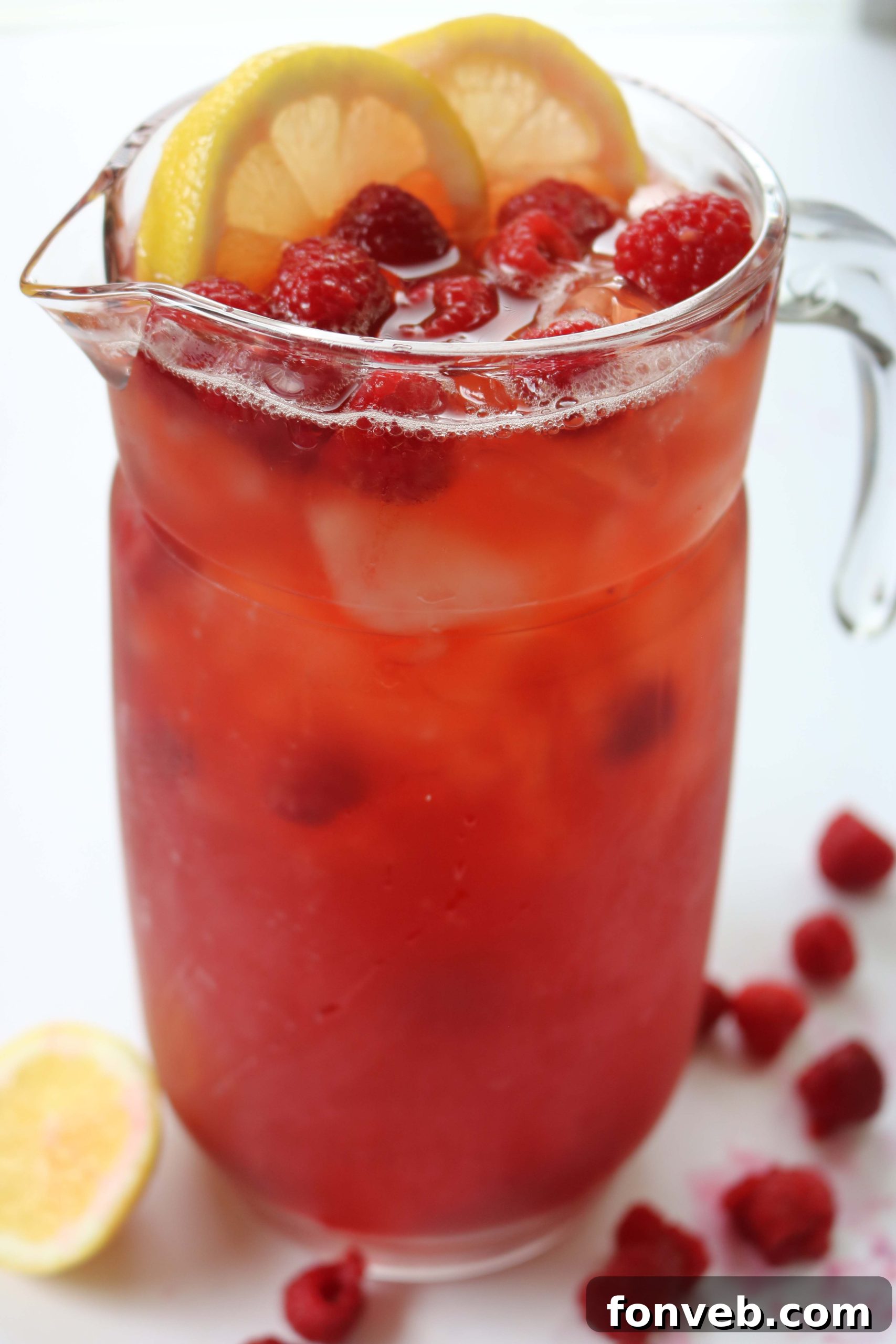 Southern Charm Raspberry Sweet Tea 6 A vertical shot of a tall glass of raspberry sweet tea, showing its refreshing qualities with ice and raspberry garnish.